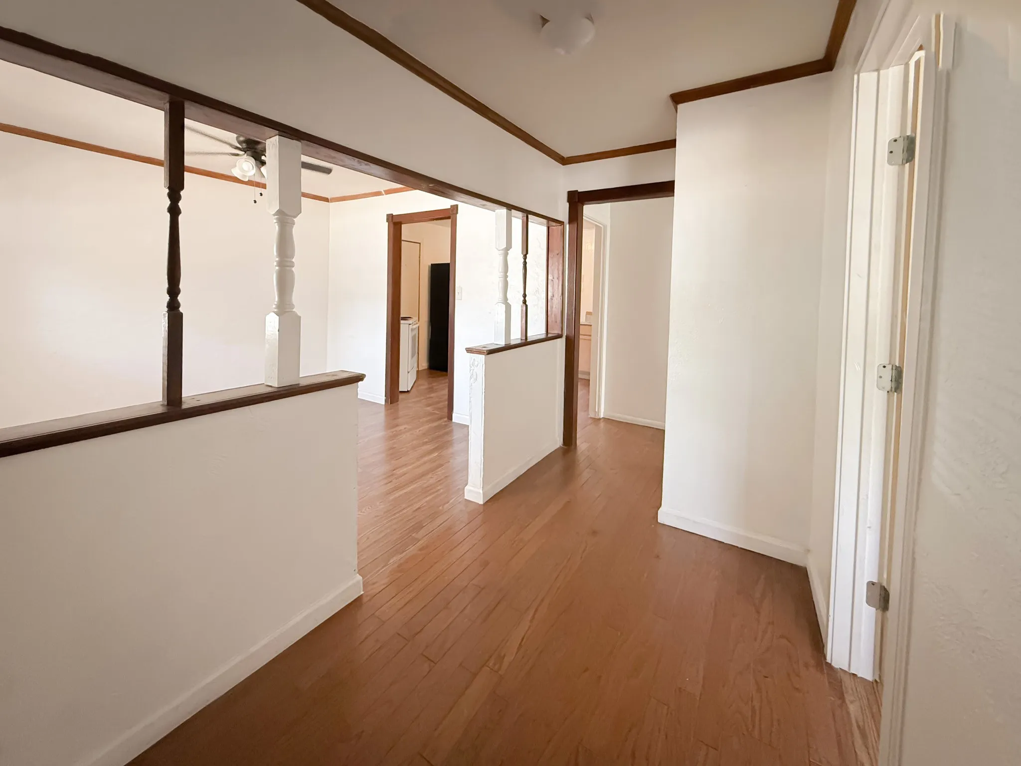 Hardwood-finish flooring throughout, white walls, and dark wood trim
