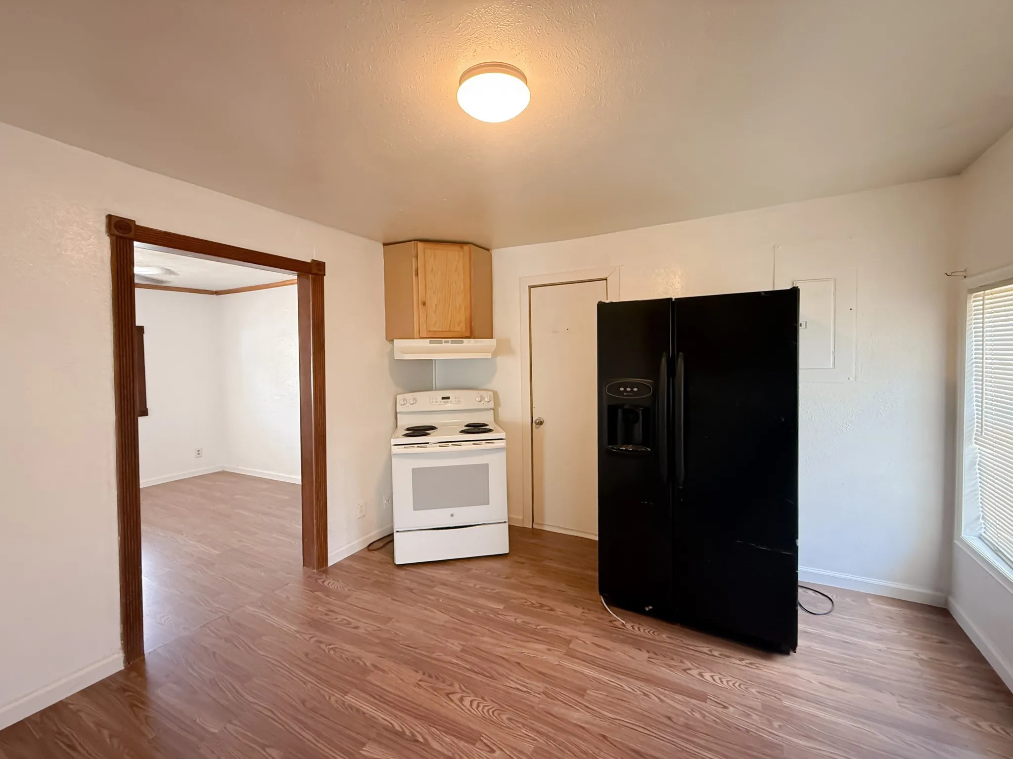 Wood-finish flooring throughout, white walls, and a recessed ceiling light