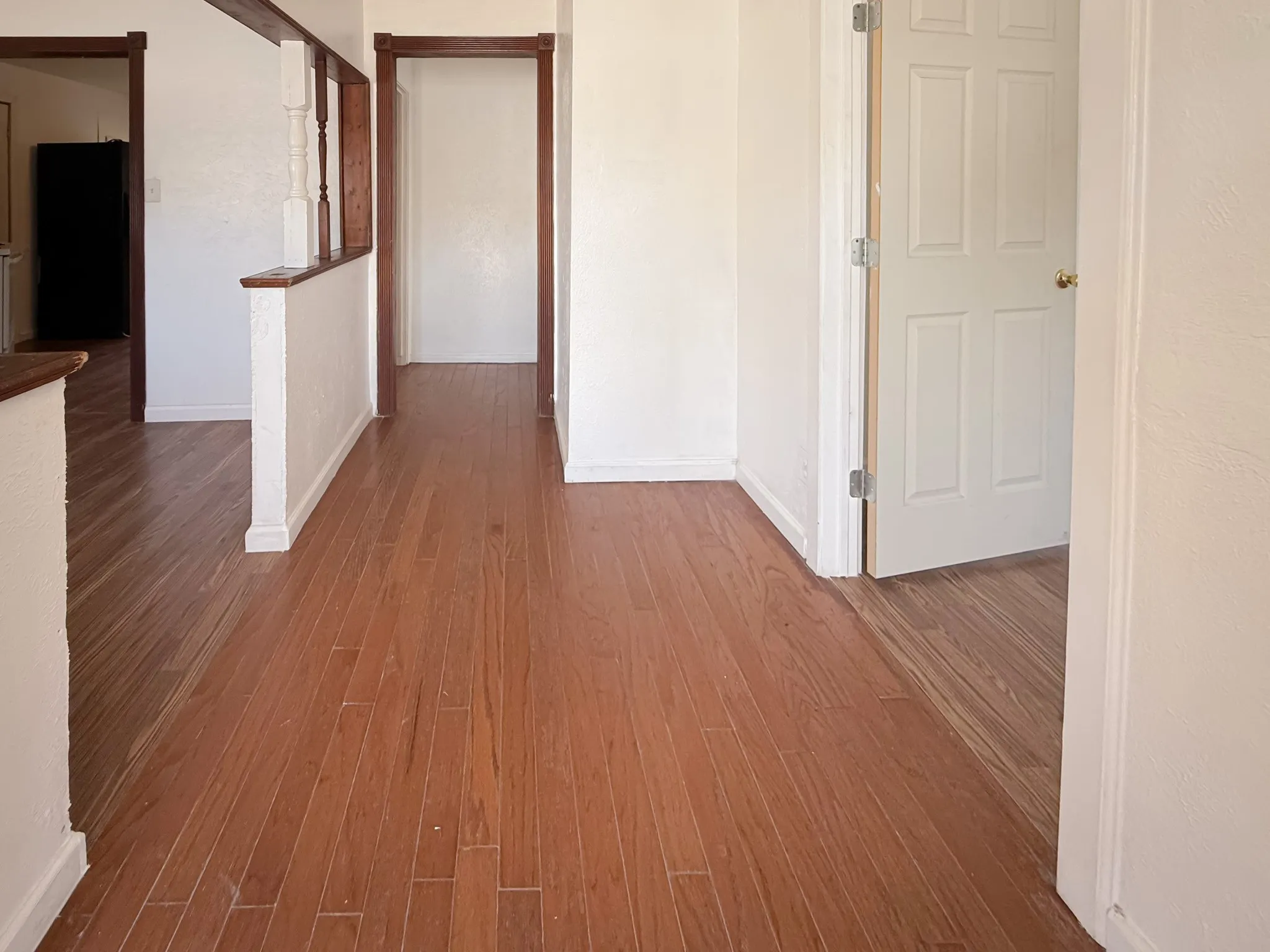 Wood-finish flooring throughout, white painted walls, and wood trim accents