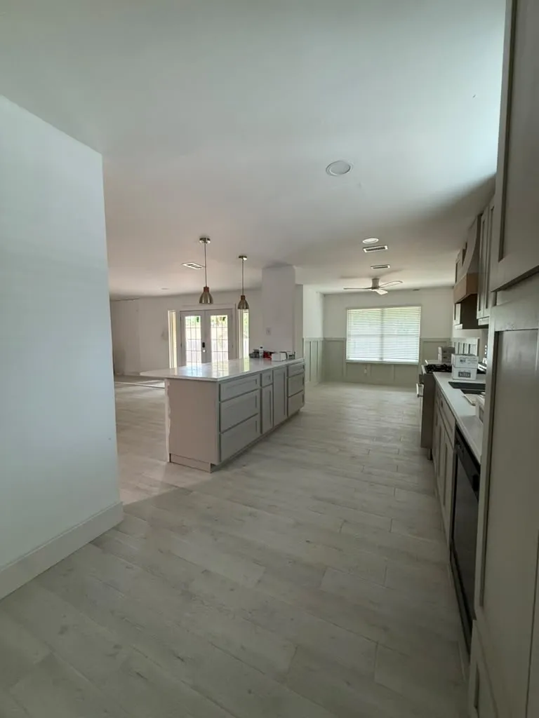 Kitchen with a center island, wood-finish flooring, recessed lighting, pendant lighting, and stainless steel appliances