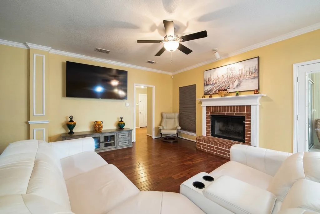 Living area featuring ornamental molding, hardwood / wood-style floors, a fireplace, and visible vents
