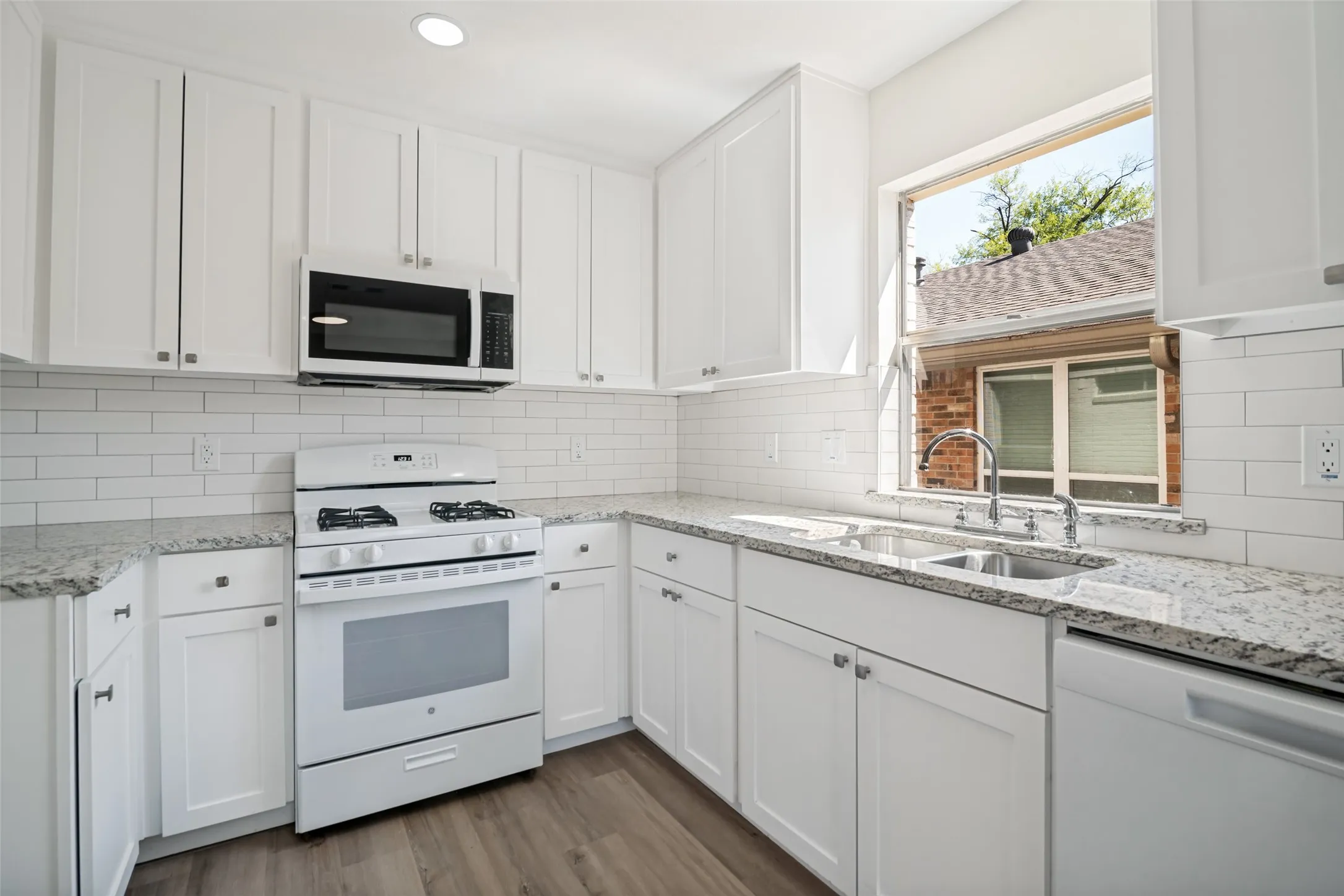 Granite countertops and whited subway tile backsplash