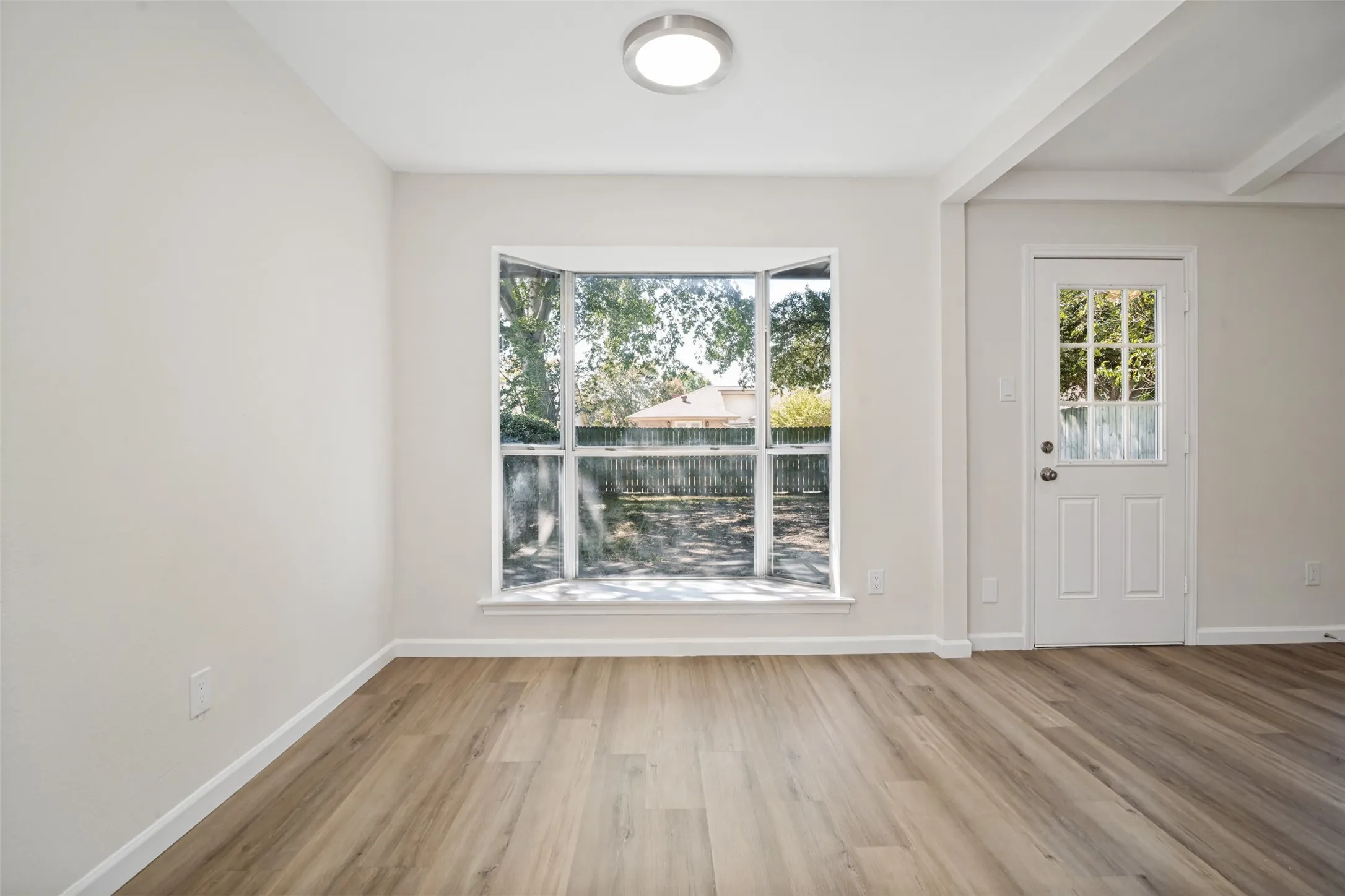 Bay windows overlooking the shaded backyard