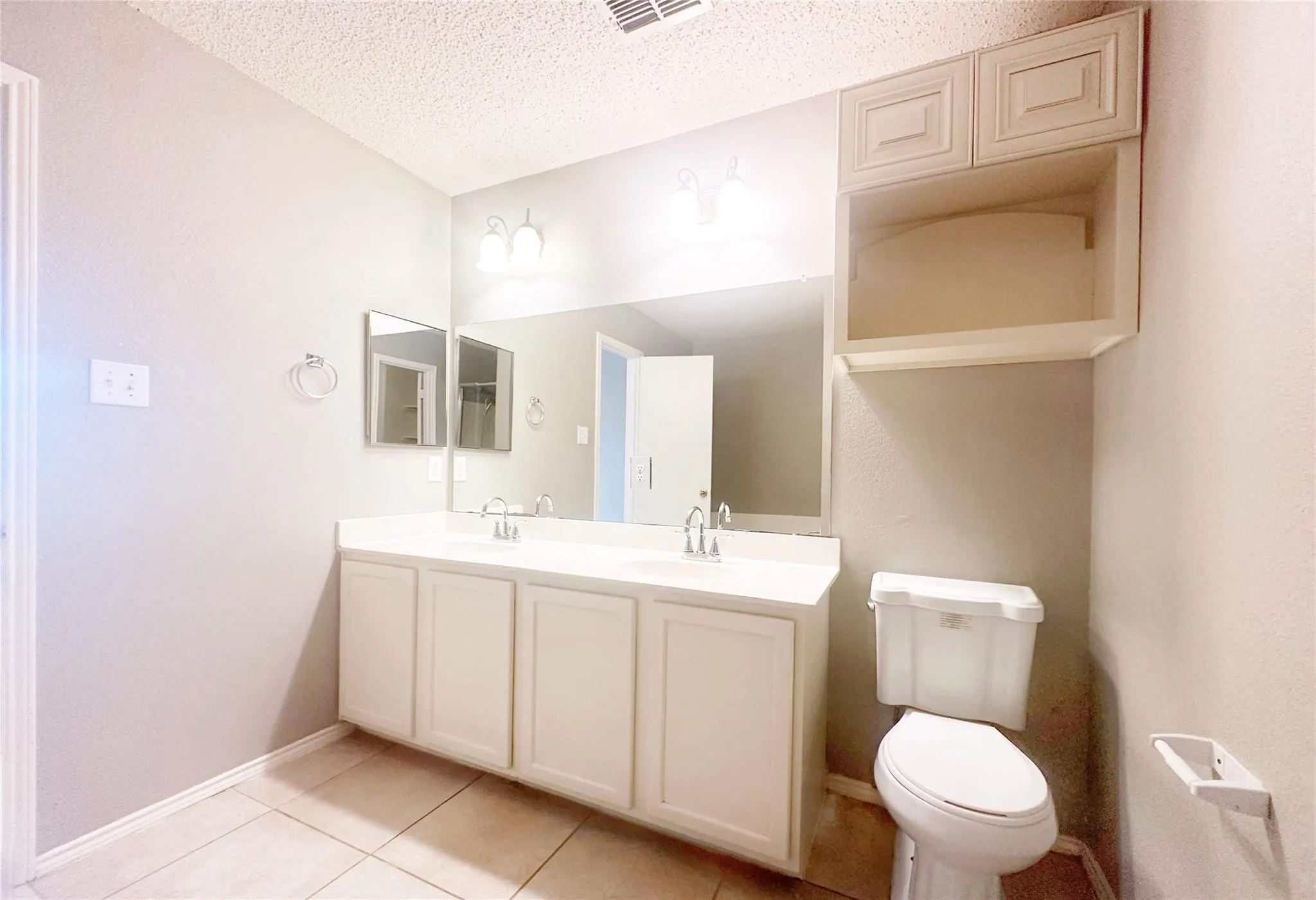 Double vanity with undermount sinks, white cabinetry, and matching countertop