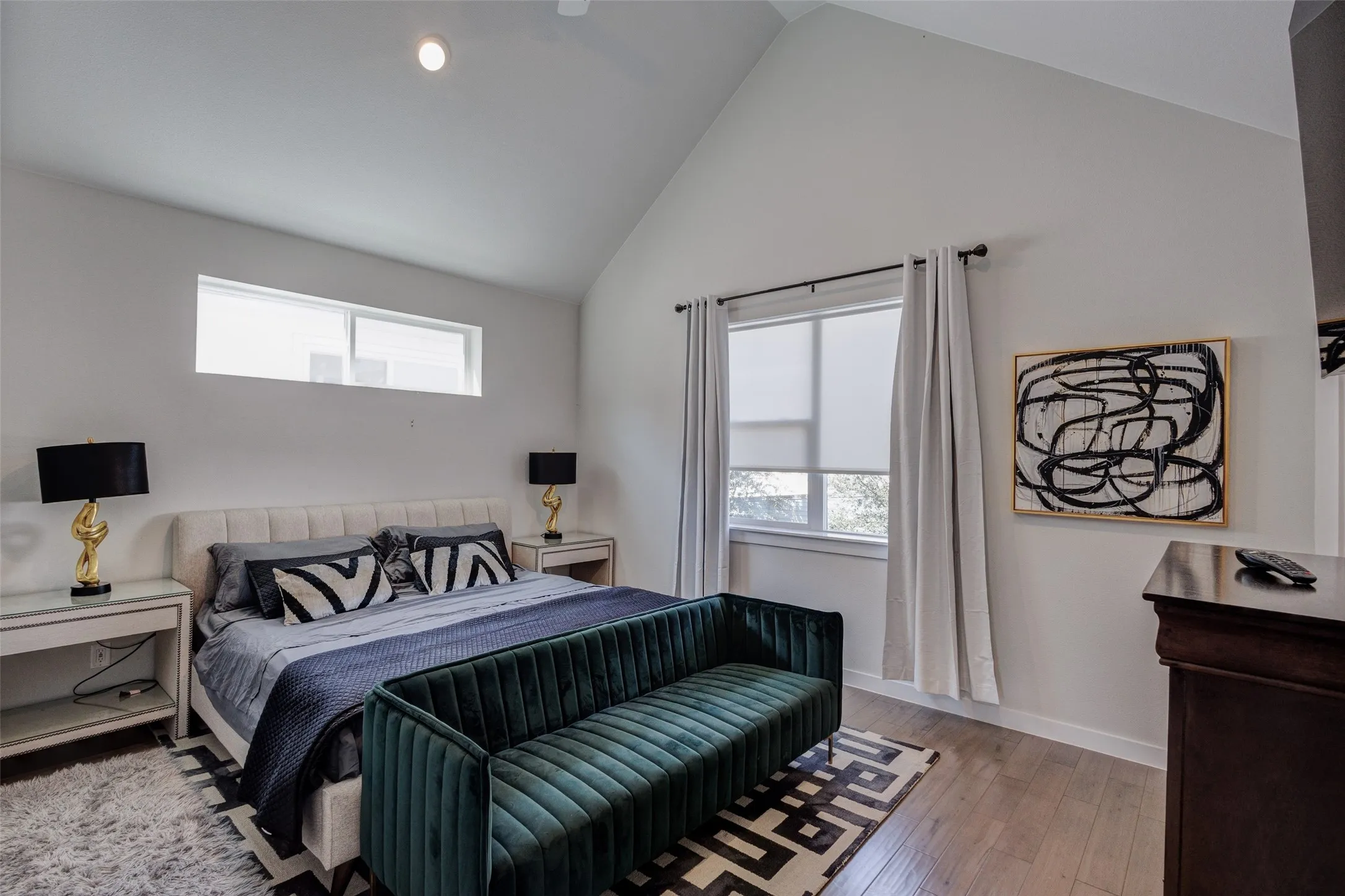 Primary bedroom with ceiling fan and vaulted ceiling