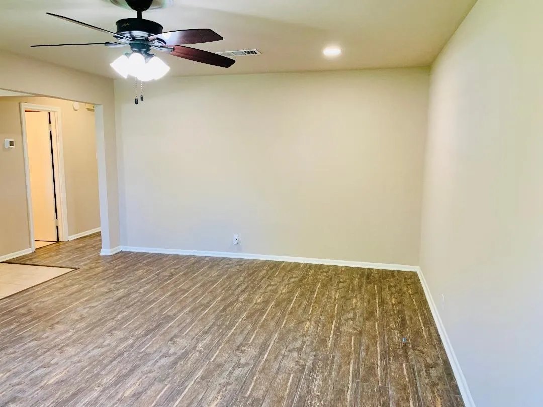 Wood-finish flooring throughout, ceiling fan with integrated lighting, recessed ceiling lighting, light neutral wall tones, and white trim