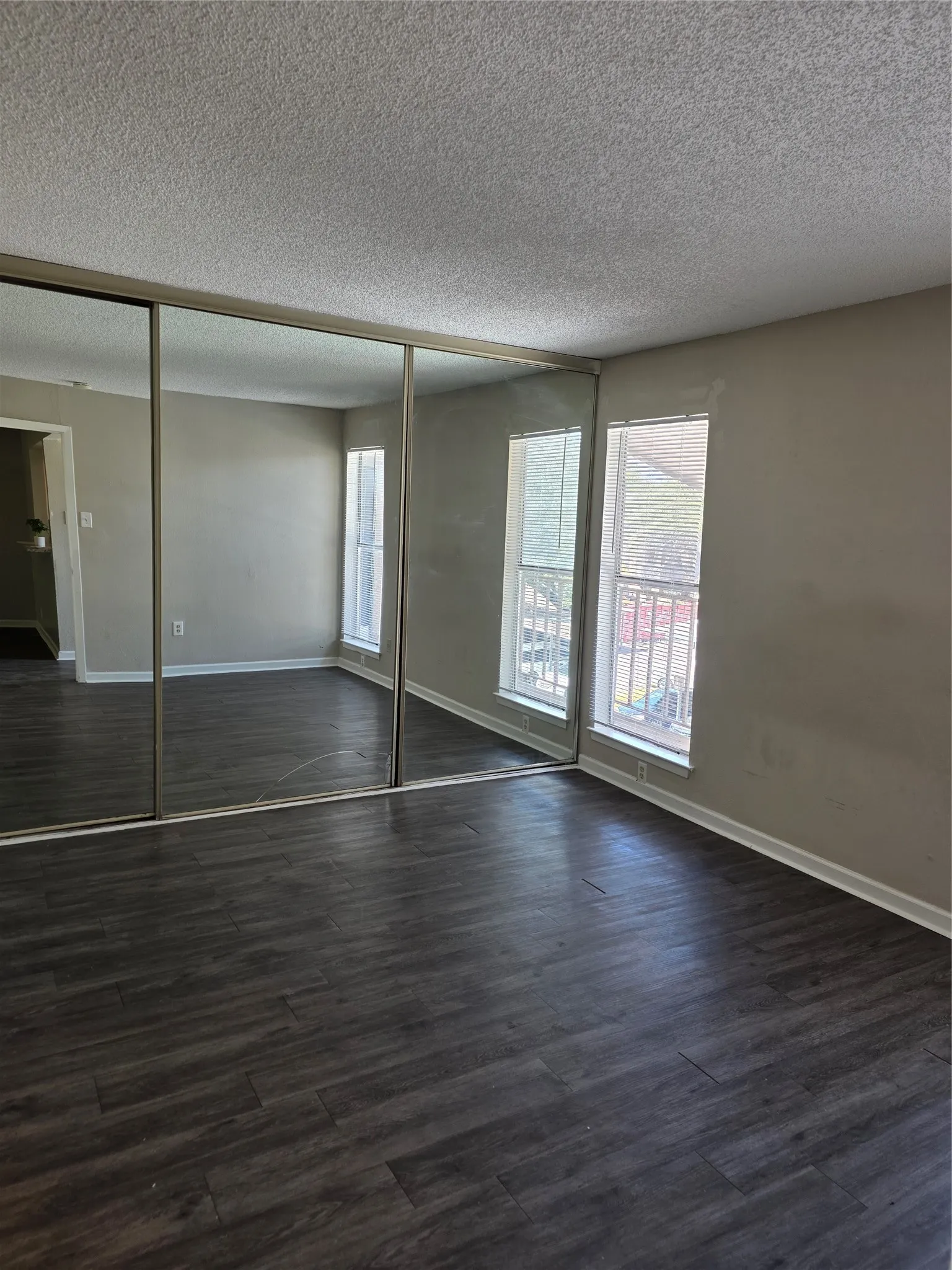 Wood-finish flooring with a neutral paint palette and multiple windows