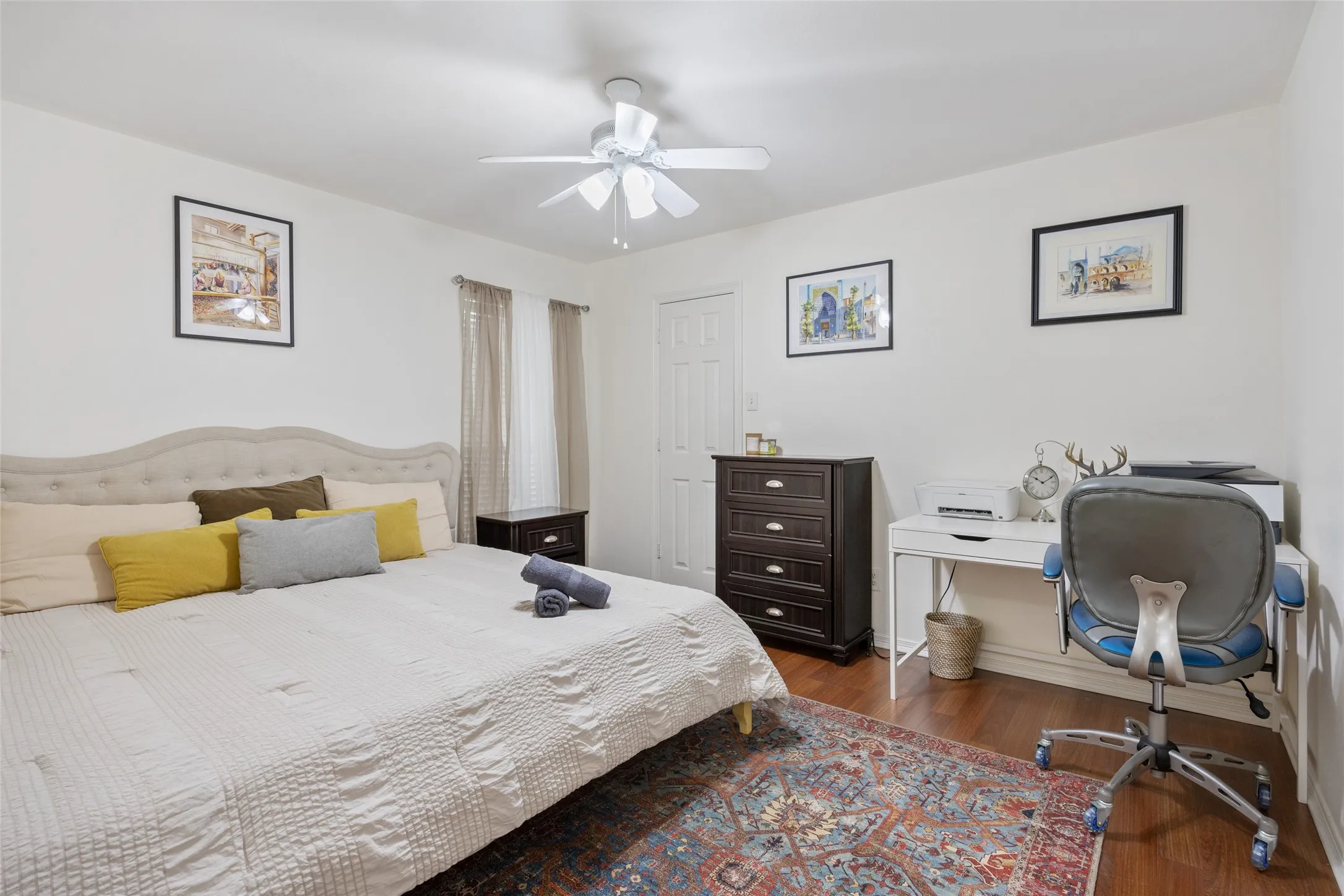 Hardwood-style flooring, white walls, and a ceiling fan with integrated lighting