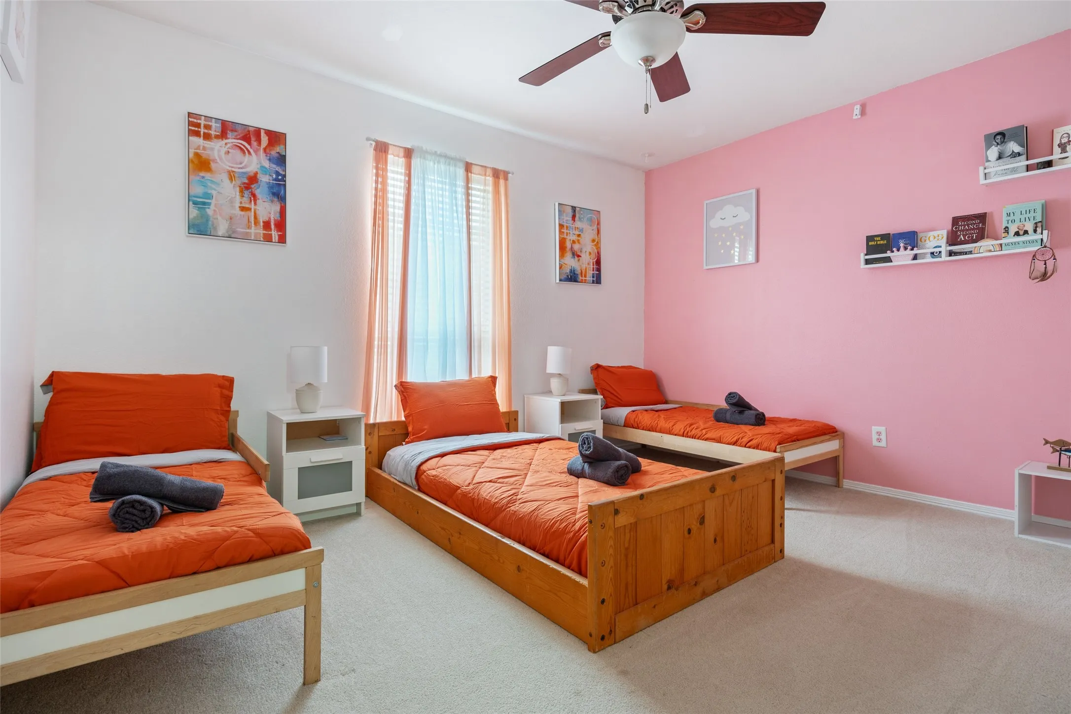 Ceiling fan with light fixture, window with blinds and sheer curtains, wall-mounted shelving, and carpeted flooring