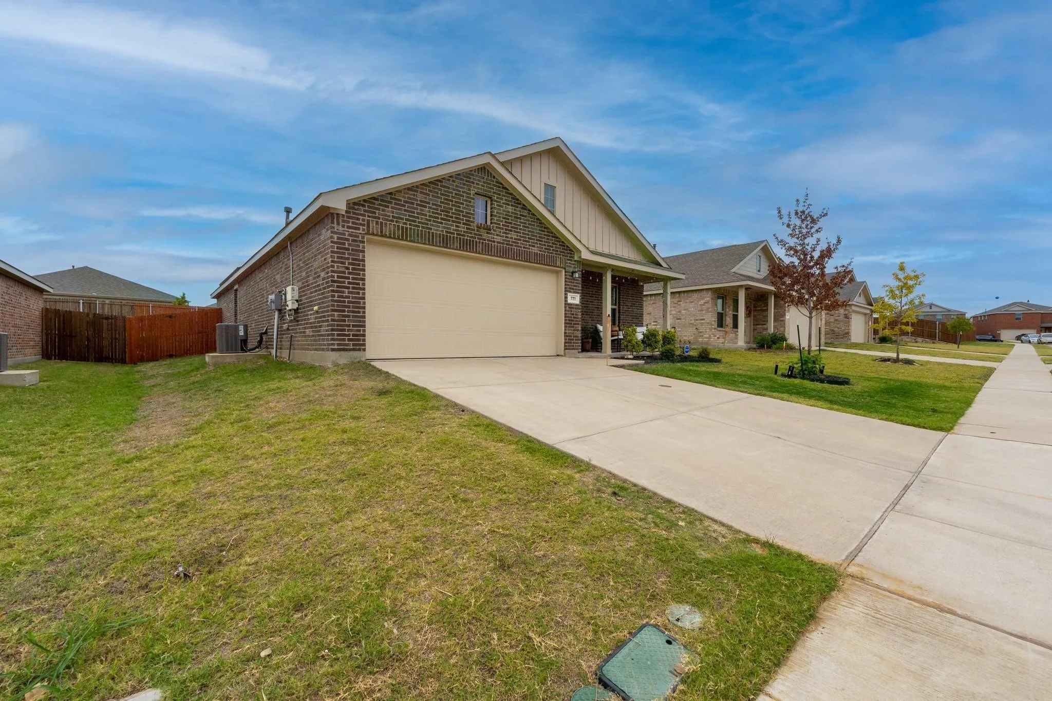 Craftsman house with central AC unit, a front lawn, and a garage