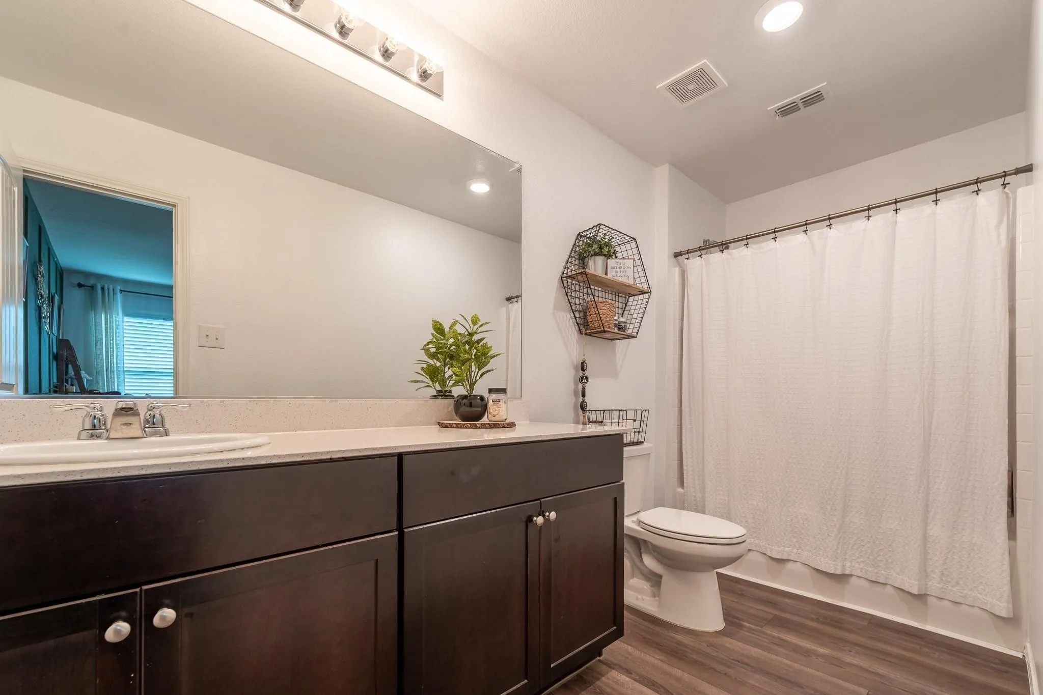 Bathroom featuring vanity, hardwood / wood-style flooring, and toilet
