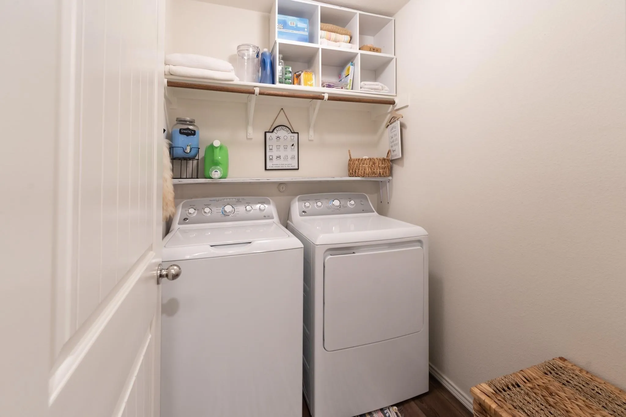 Laundry room with hardwood / wood-style flooring and washer and clothes dryer