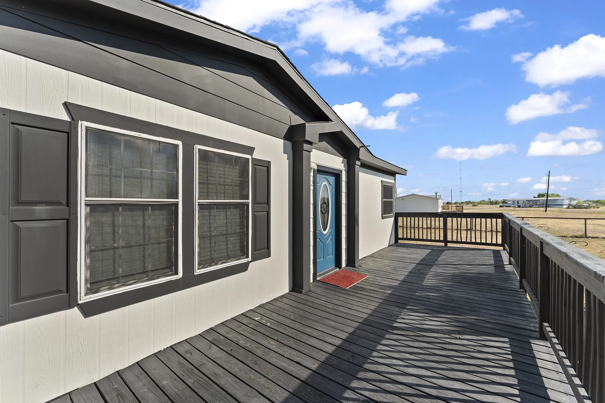 Spacious front porch with attractive railing, ample room for outdoor seating, and a welcoming entryway.