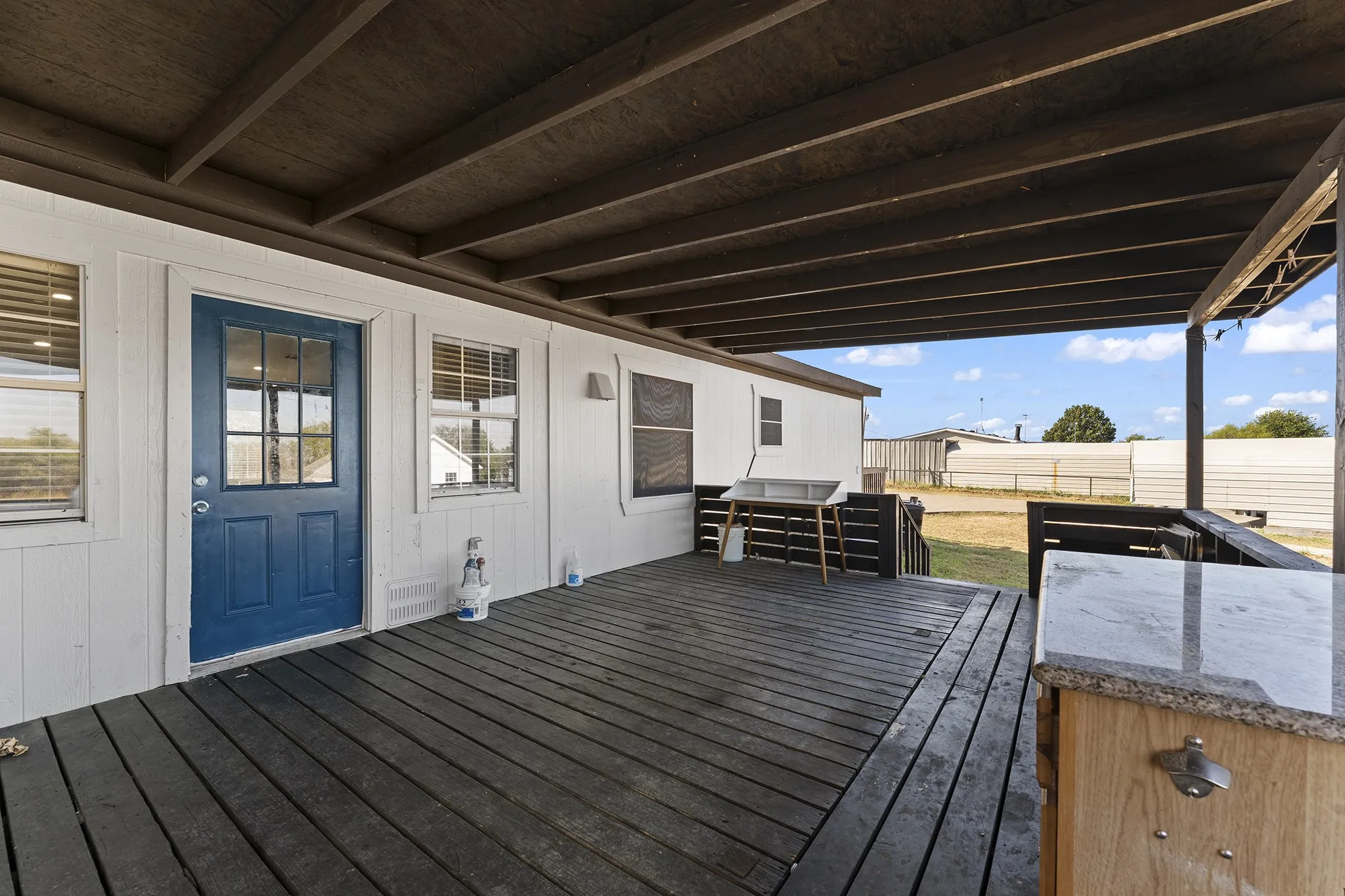 Spacious covered back deck with plenty of room for outdoor seating, dining, and entertaining while enjoying views of the backyard.