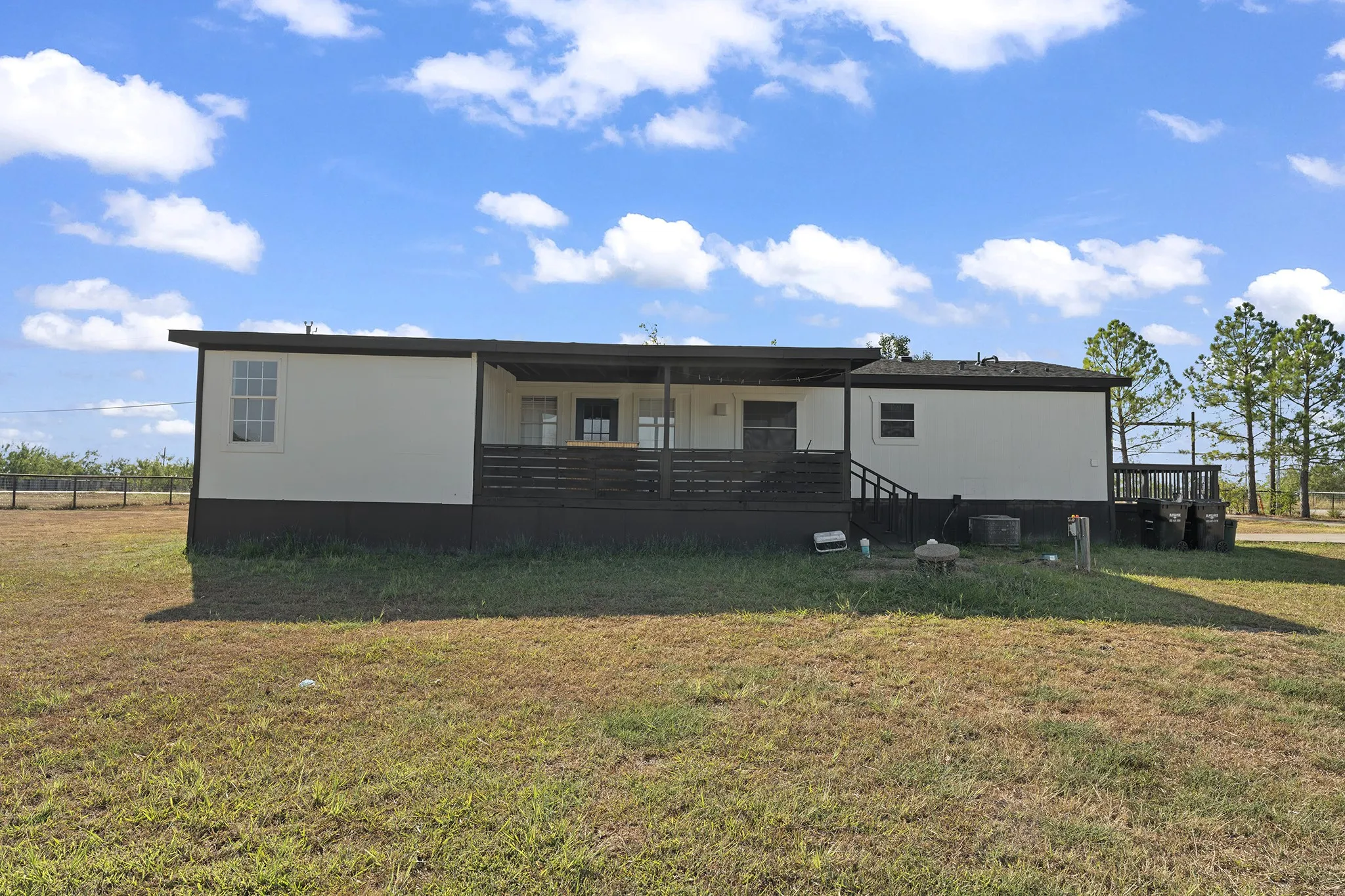 Rear exterior featuring a spacious covered deck overlooking the expansive backyard—ideal for relaxing, entertaining, and enjoying the outdoors.
