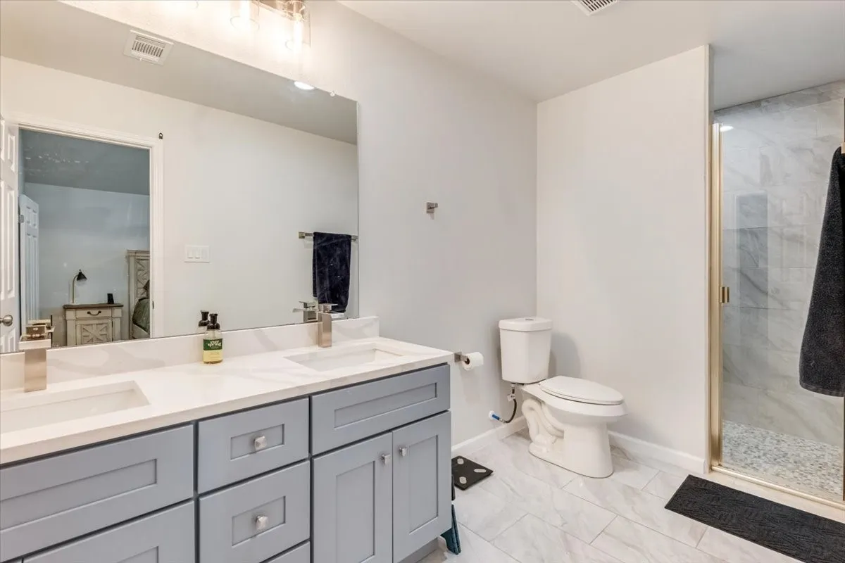 Dual vanity with light gray cabinetry and white countertops