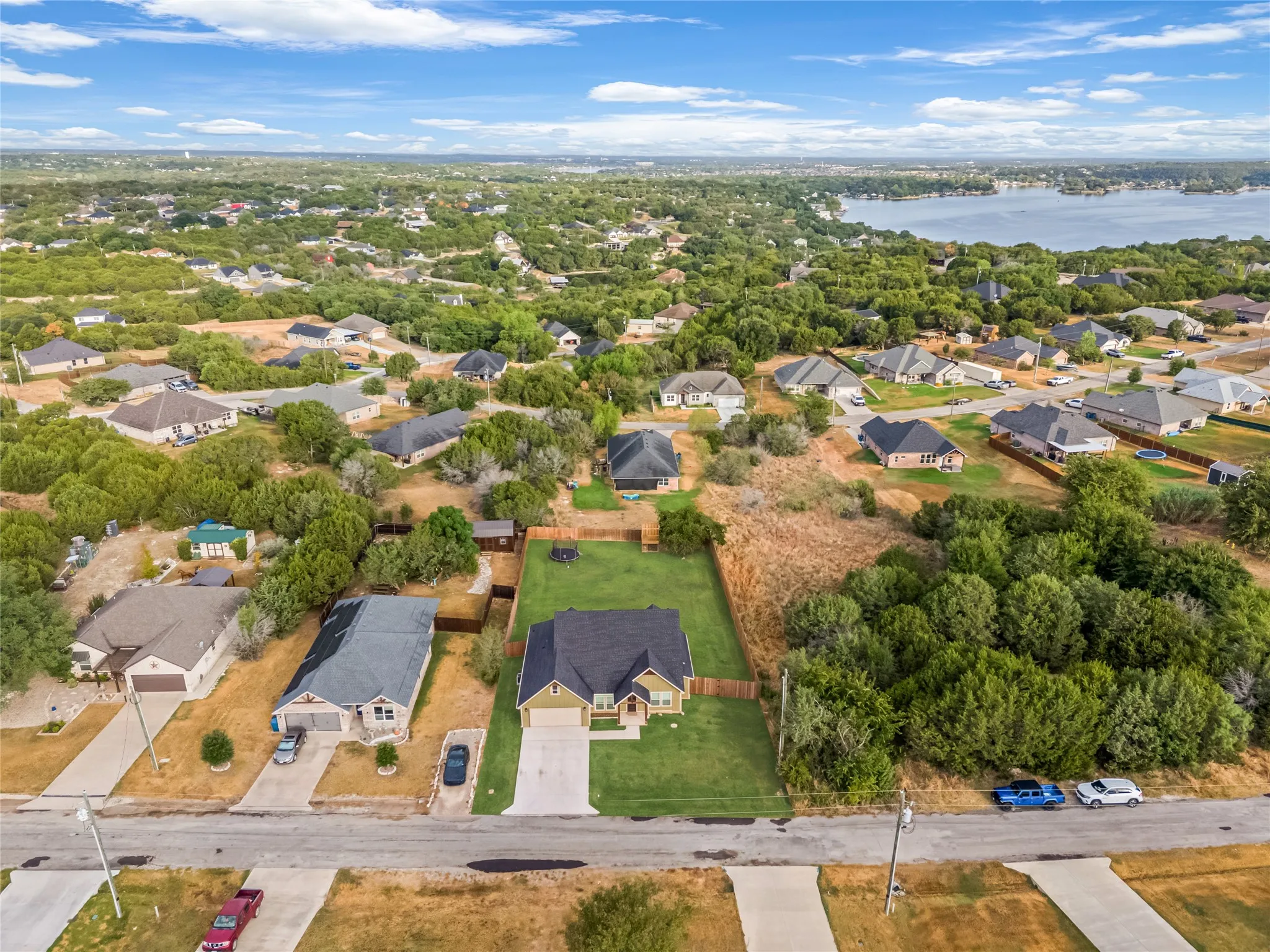 Residential neighborhood featuring mature trees and a distant body of water