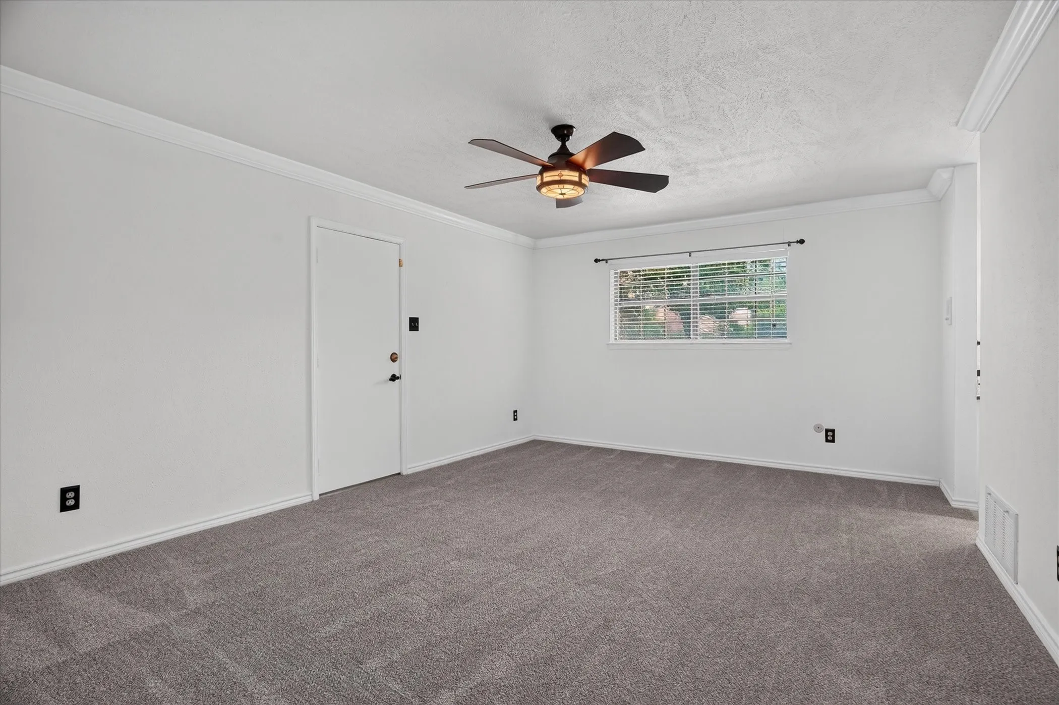 Spacious primary bedroom with an exterior door to the back patio