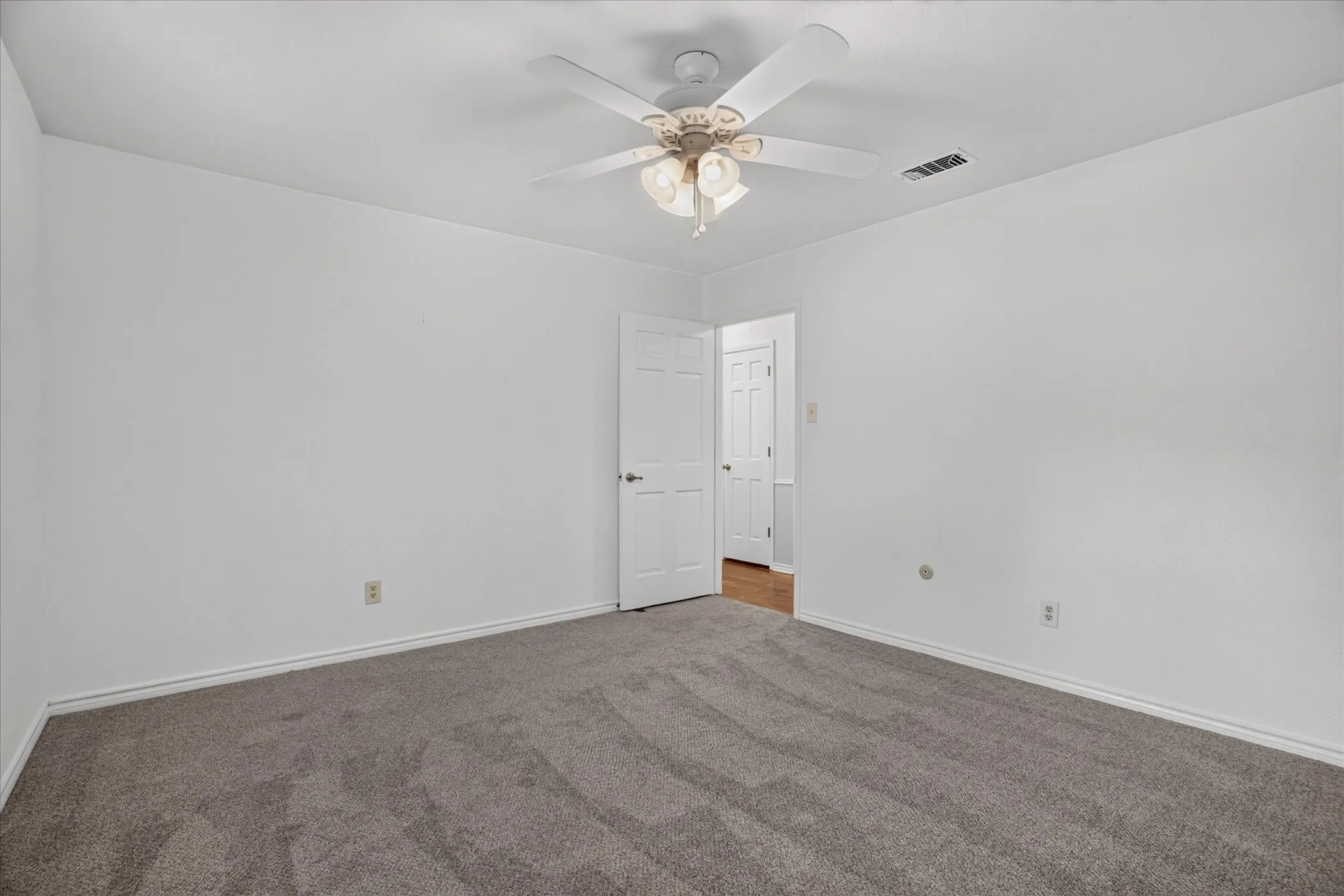 Downstairs bedroom 3 with new carpet and a walk in closet