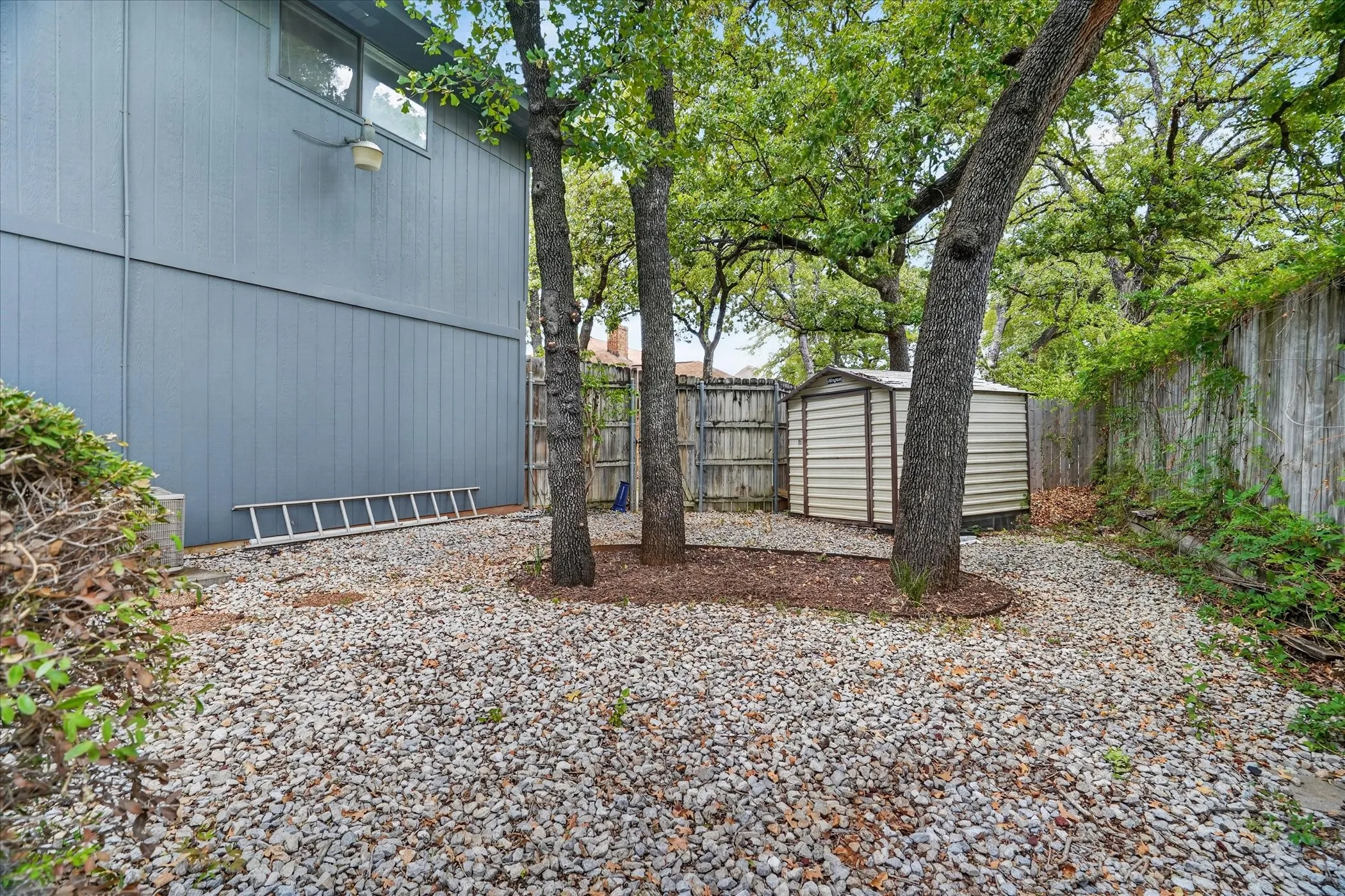 The side of the house in the back yard also has a shed