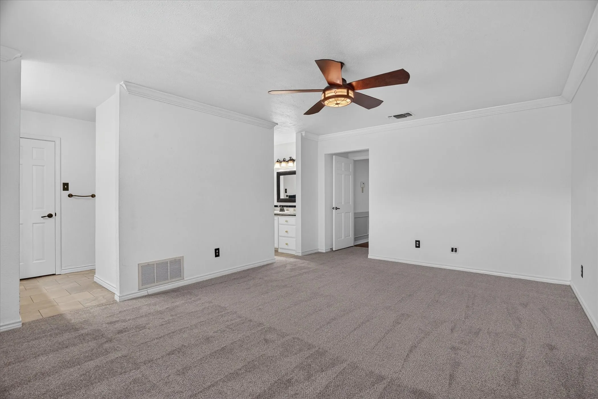 Spacious primary bedroom with an exterior door to the back patio
