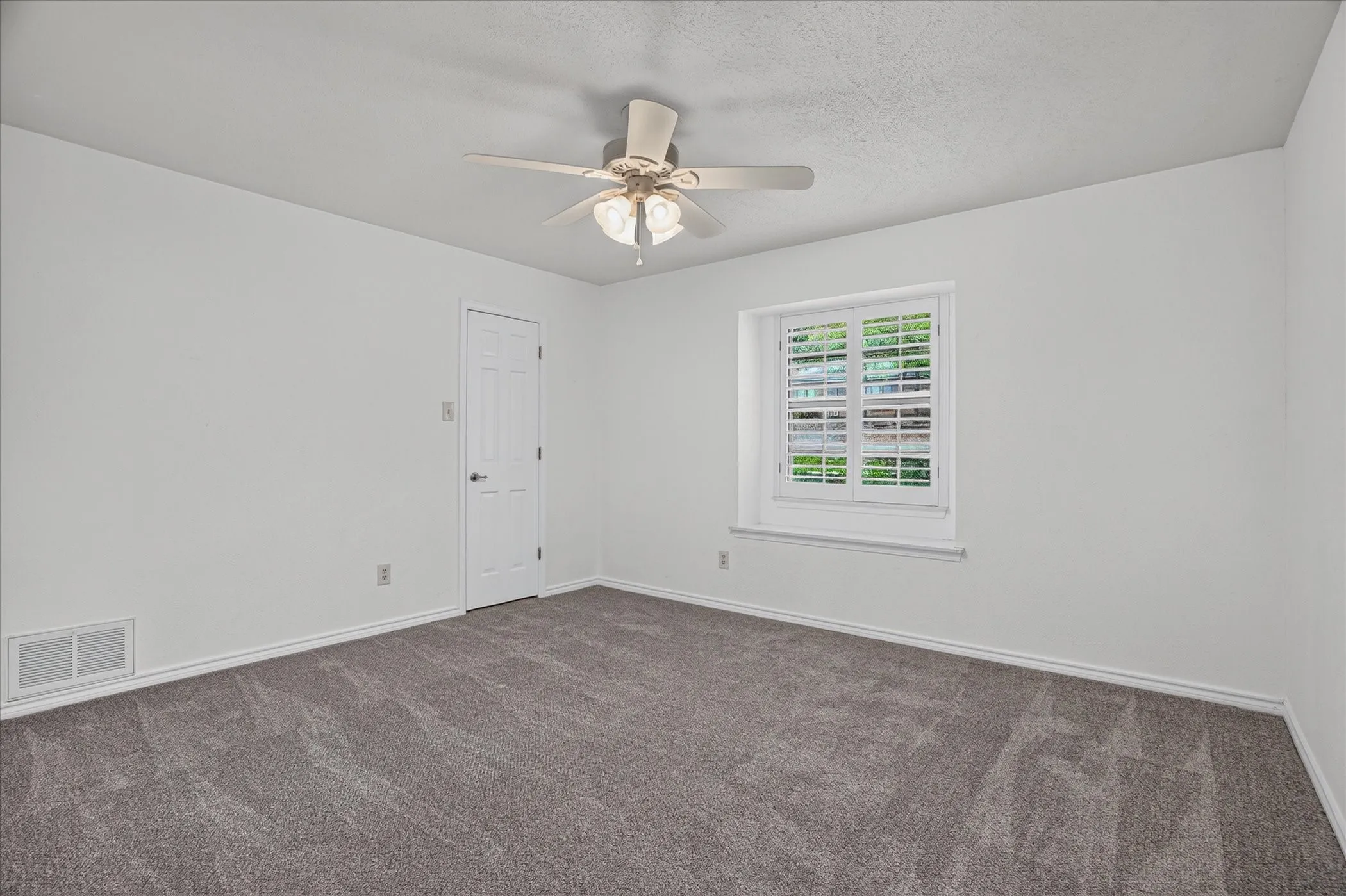 Downstairs bedroom 3 with new carpet and a walk in closet