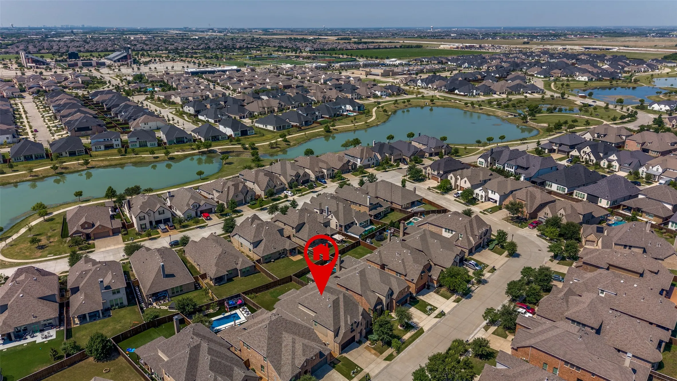 Aerial perspective of a residential community featuring numerous single-family homes with pitched roofs