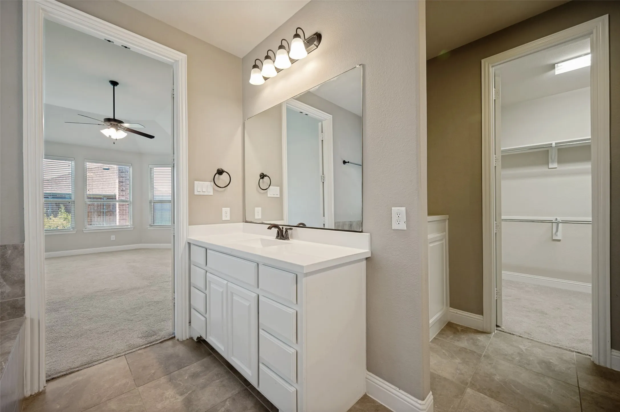 Bathroom vanity featuring a single sink, white cabinetry, and a surface-mounted mirror