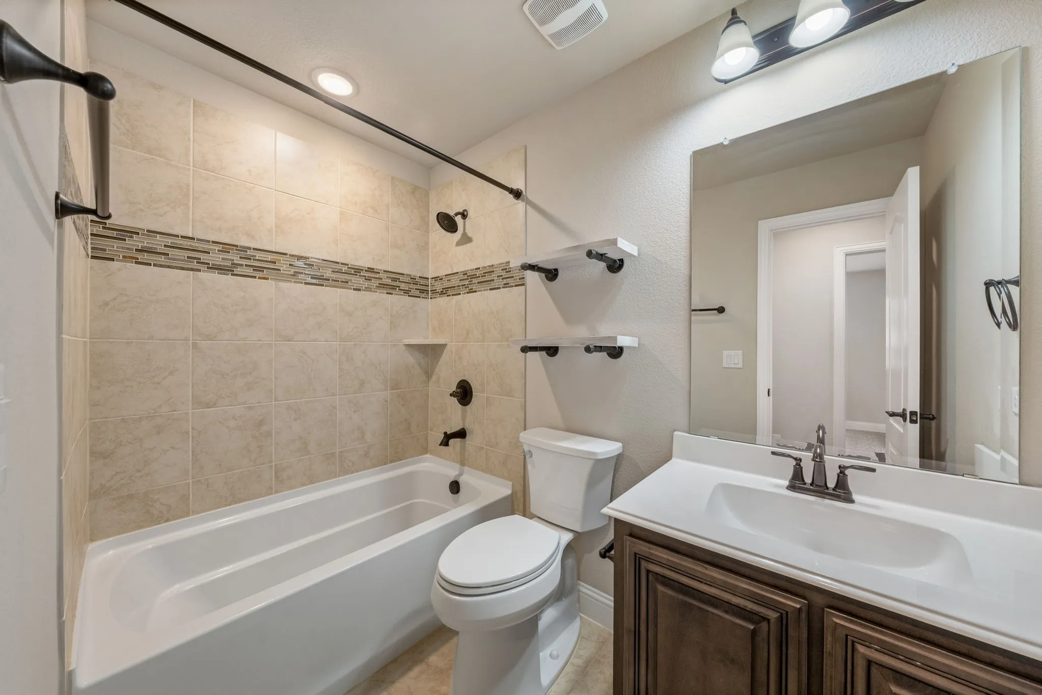Tiled shower surround with decorative accent band and built-in niche