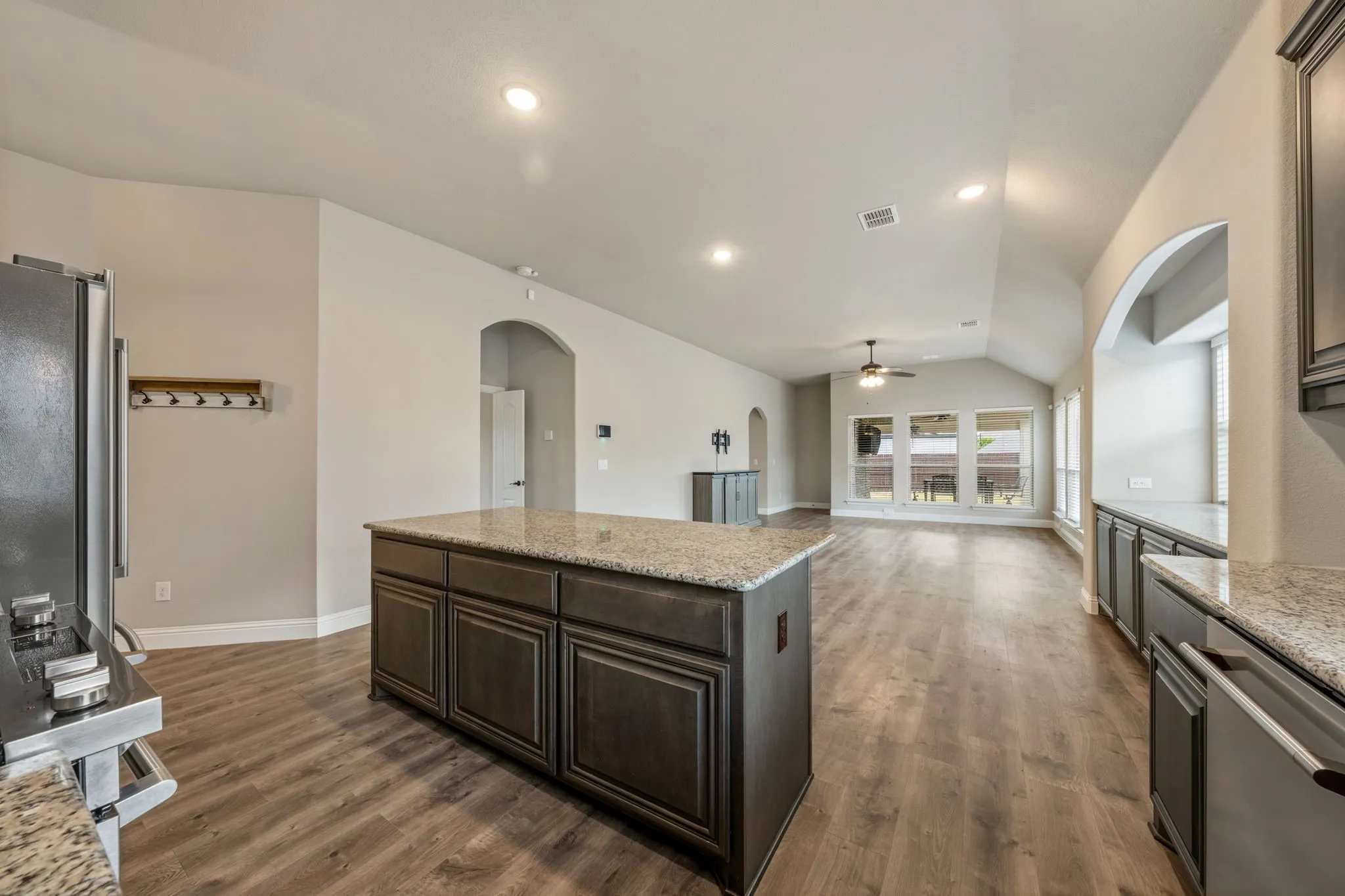 Kitchen island with granite countertop and dark wood-finish cabinetry