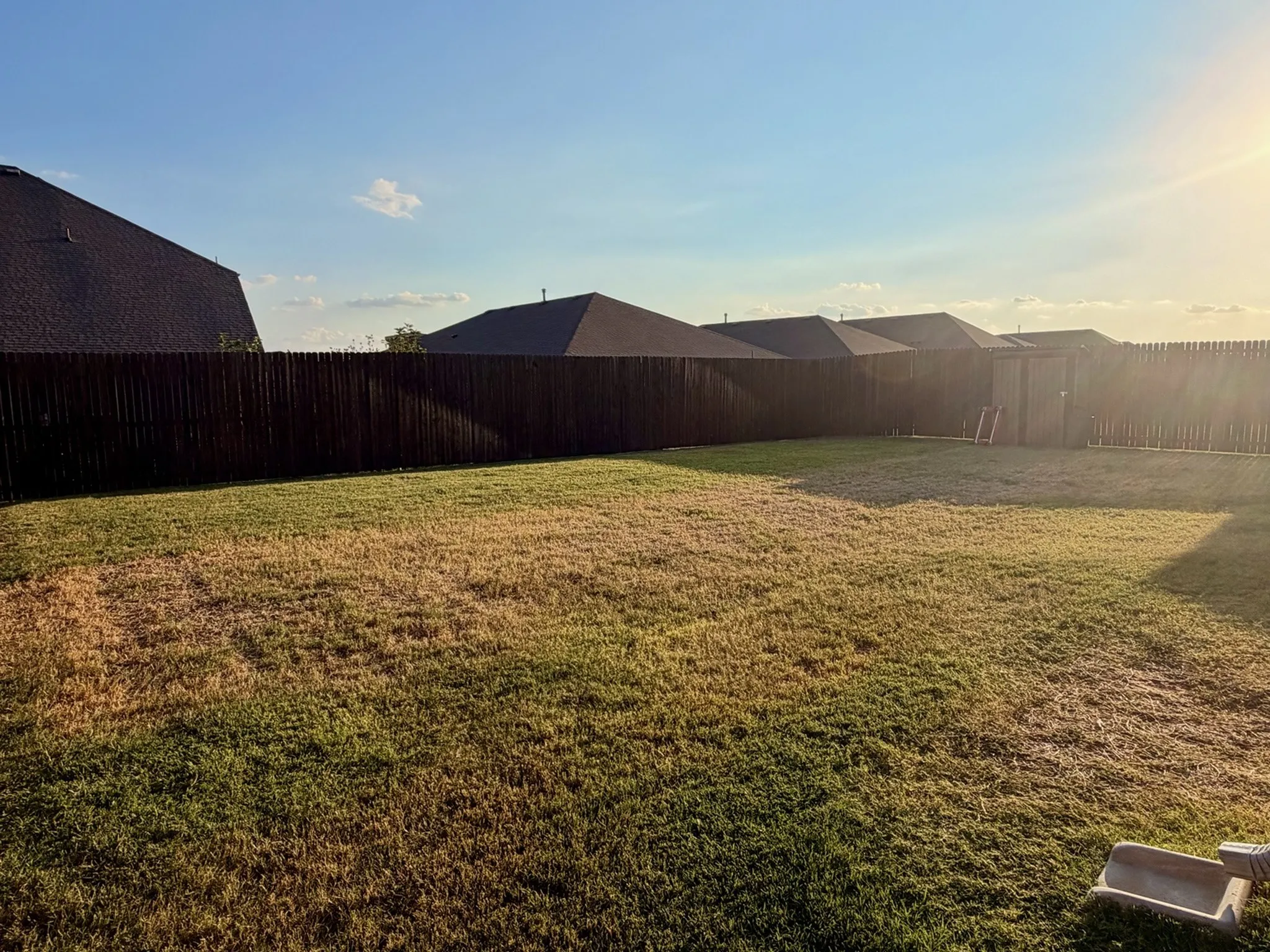 Expansive backyard featuring a privacy fence and a storage shed