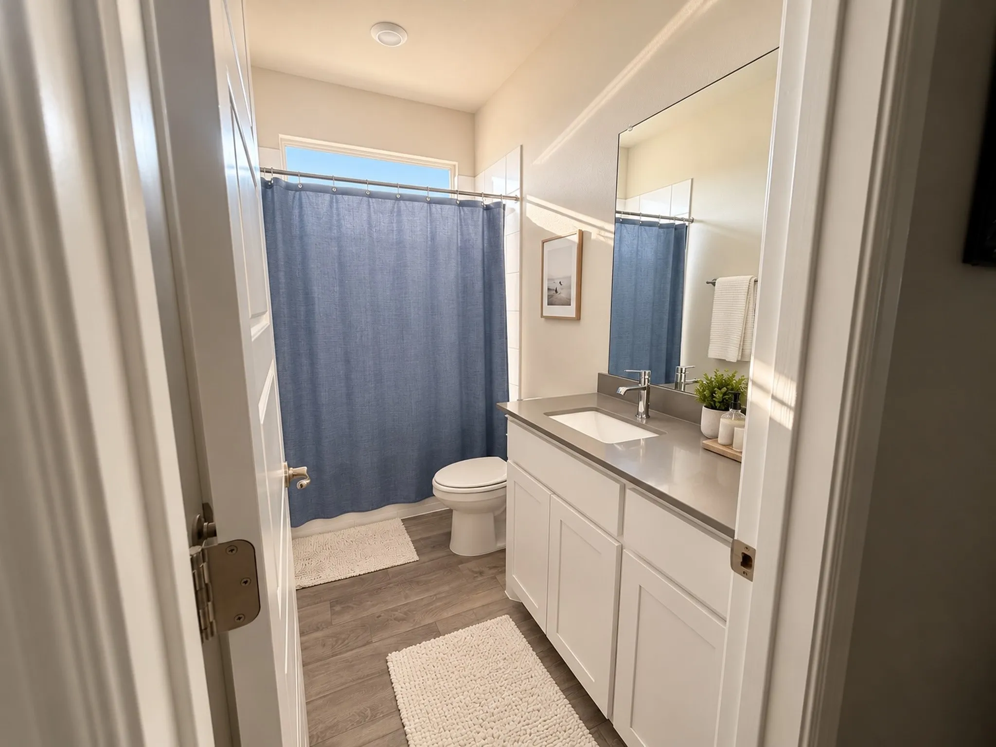 White vanity with a single basin sink, contemporary chrome faucet, and expansive wall-mounted mirror