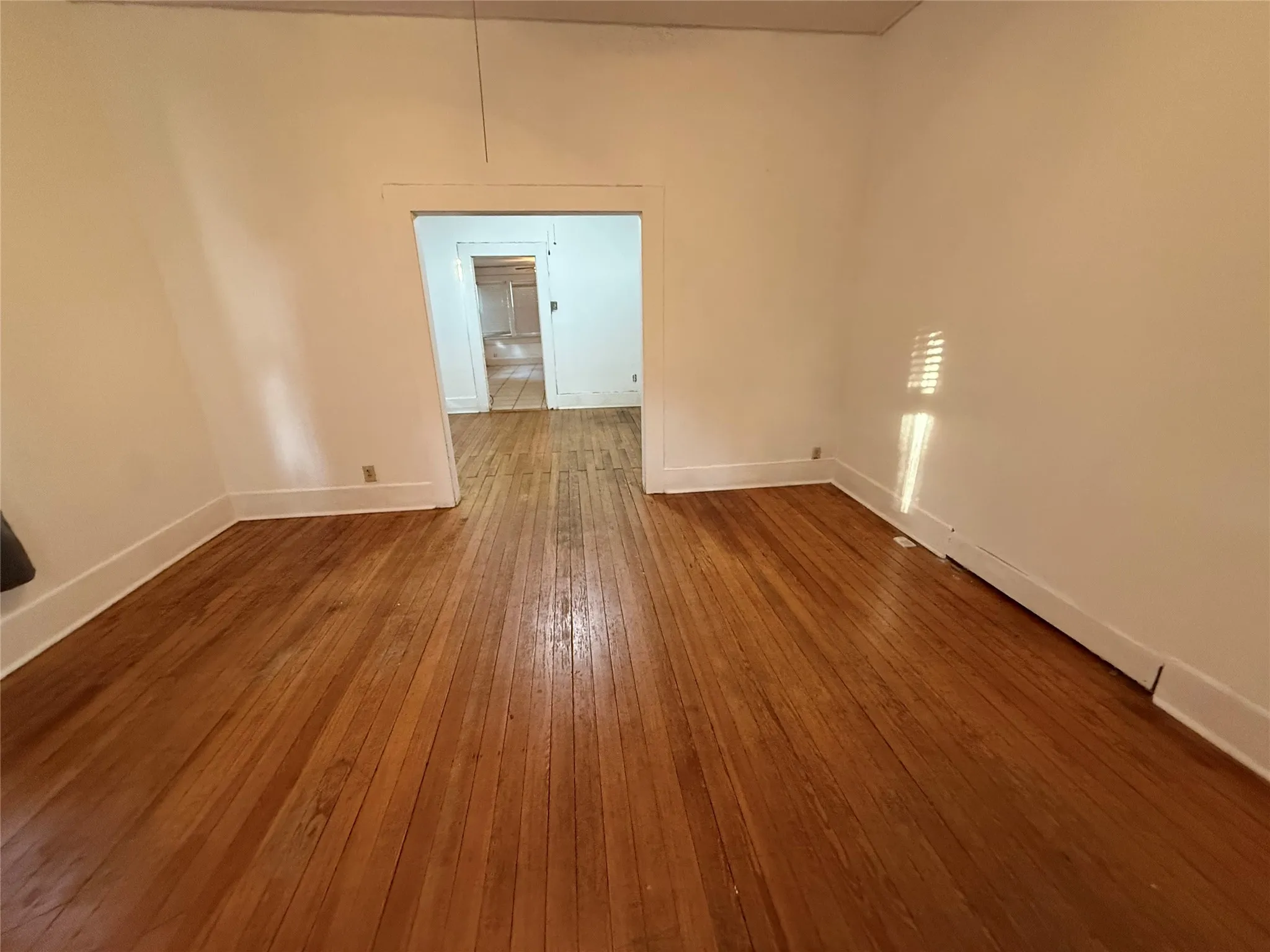 Hardwood flooring throughout, white walls, and a wide​​‌​​​​‌​​‌‌​‌‌​​​‌‌​‌​‌​‌​​​‌​​ doorway