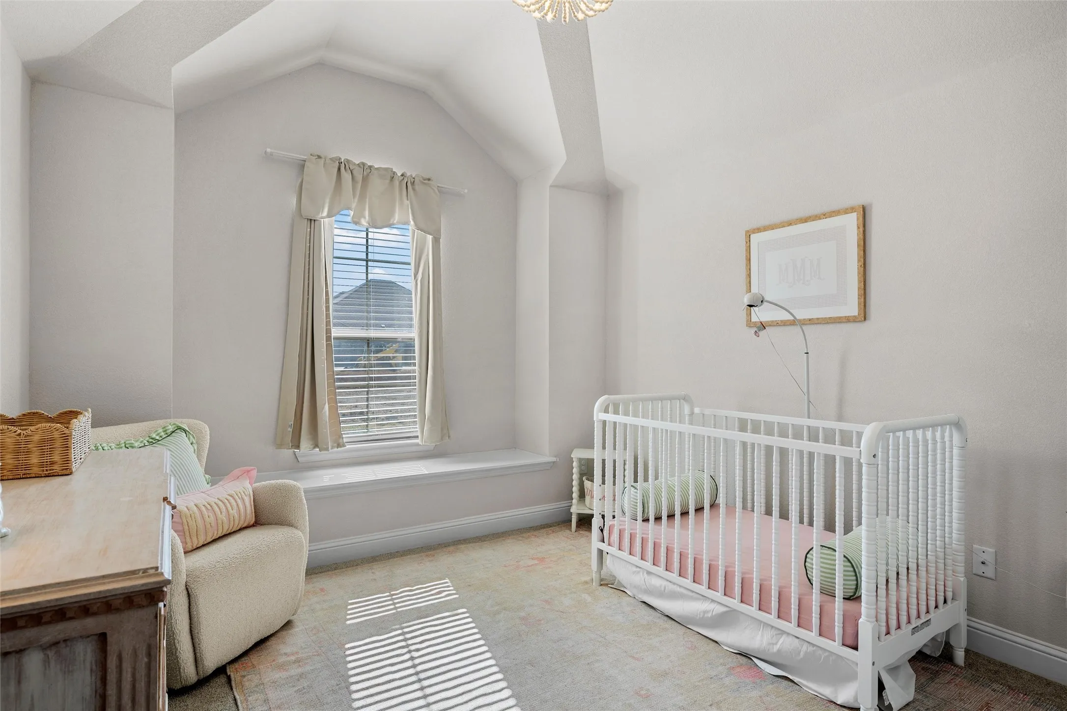 Vaulted ceiling with exposed beam, single window with blinds, window seat, and neutral wall tones