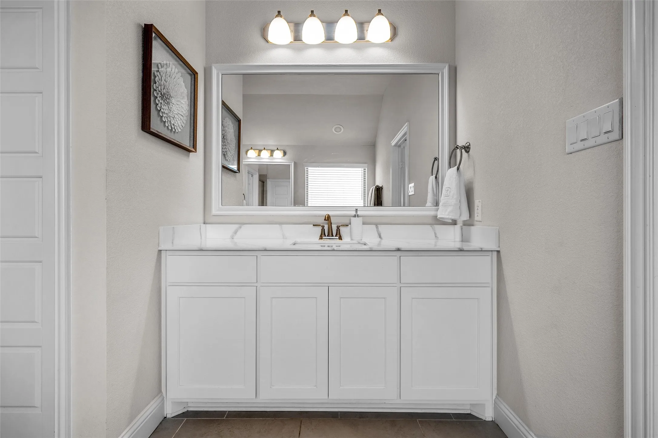 White vanity with dual cabinet doors and three drawers, topped with a white stone-finish countertop and an integrated sink