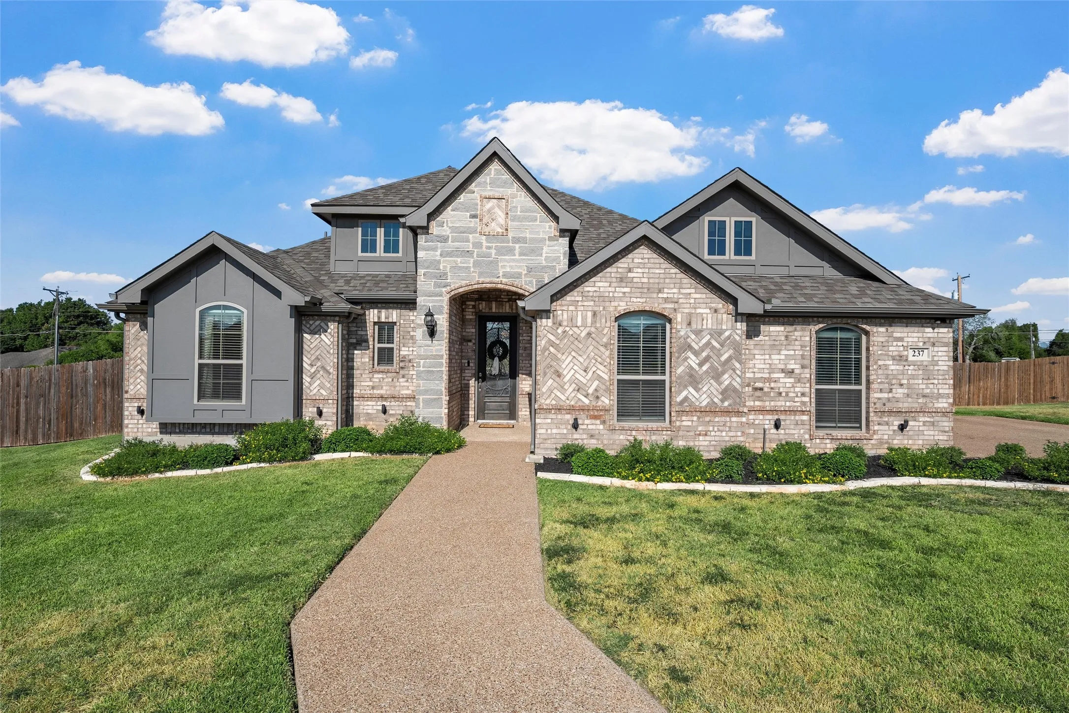 Stone and brick exterior with a gabled roof and arched entry