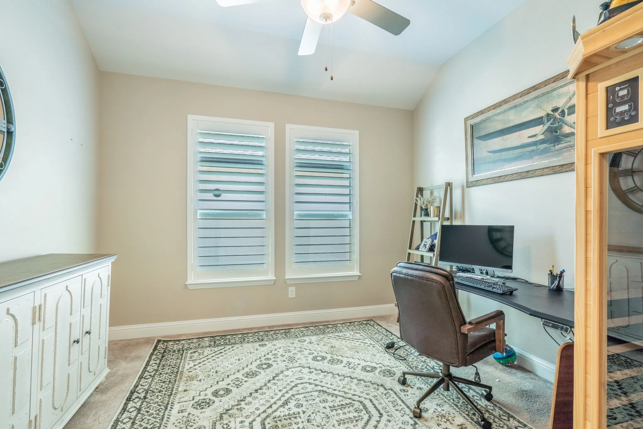 Vaulted ceiling with ceiling fan, dual windows with horizontal blinds, neutral wall paint, and carpeted flooring