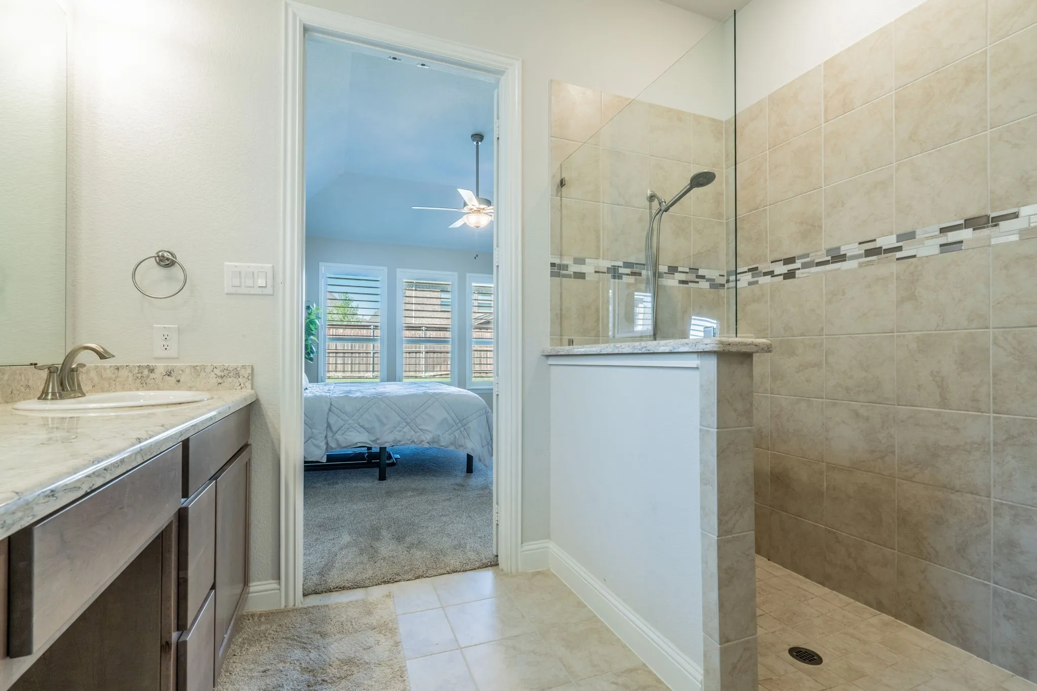 Walk-in shower with tile surround and decorative mosaic band