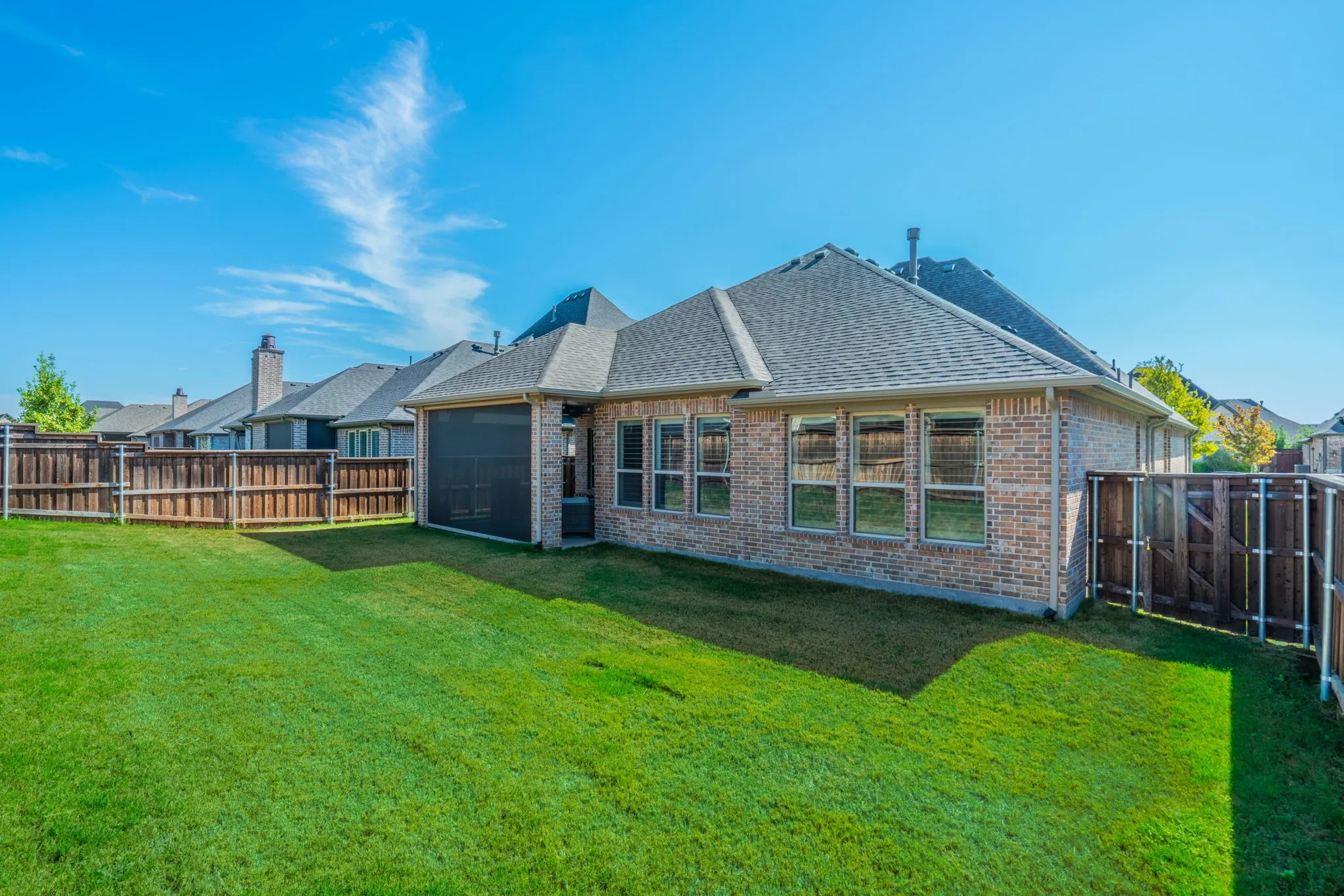 Expansive grassy yard with a full privacy fence