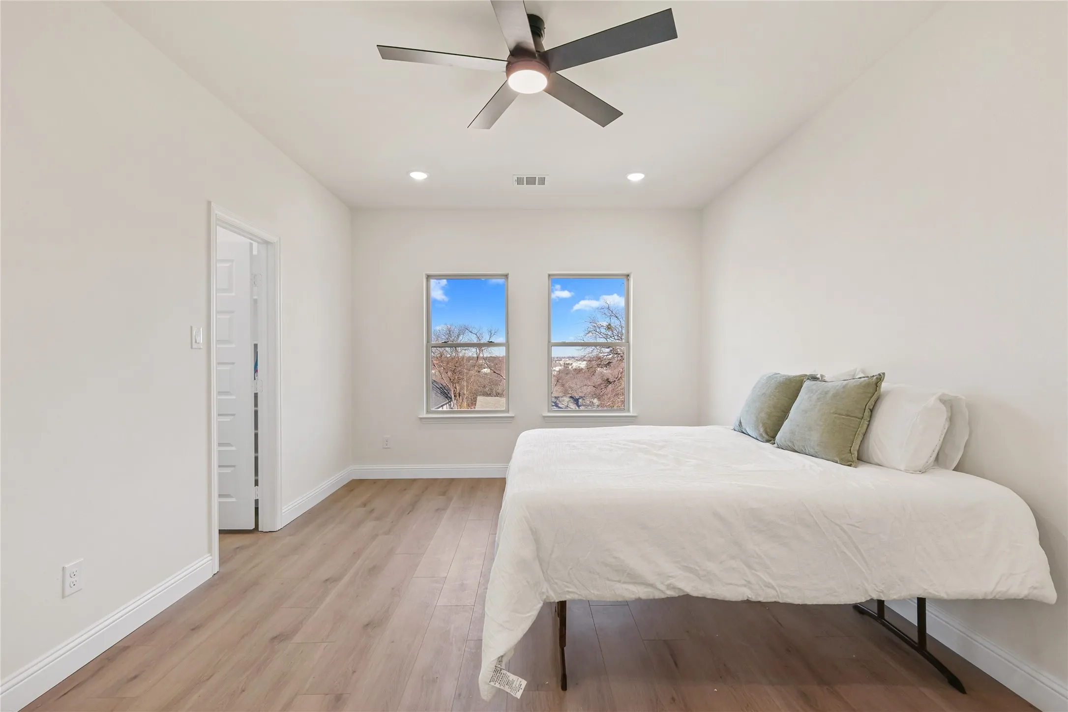 Recessed lighting, wood-finish flooring, and a contemporary ceiling fan