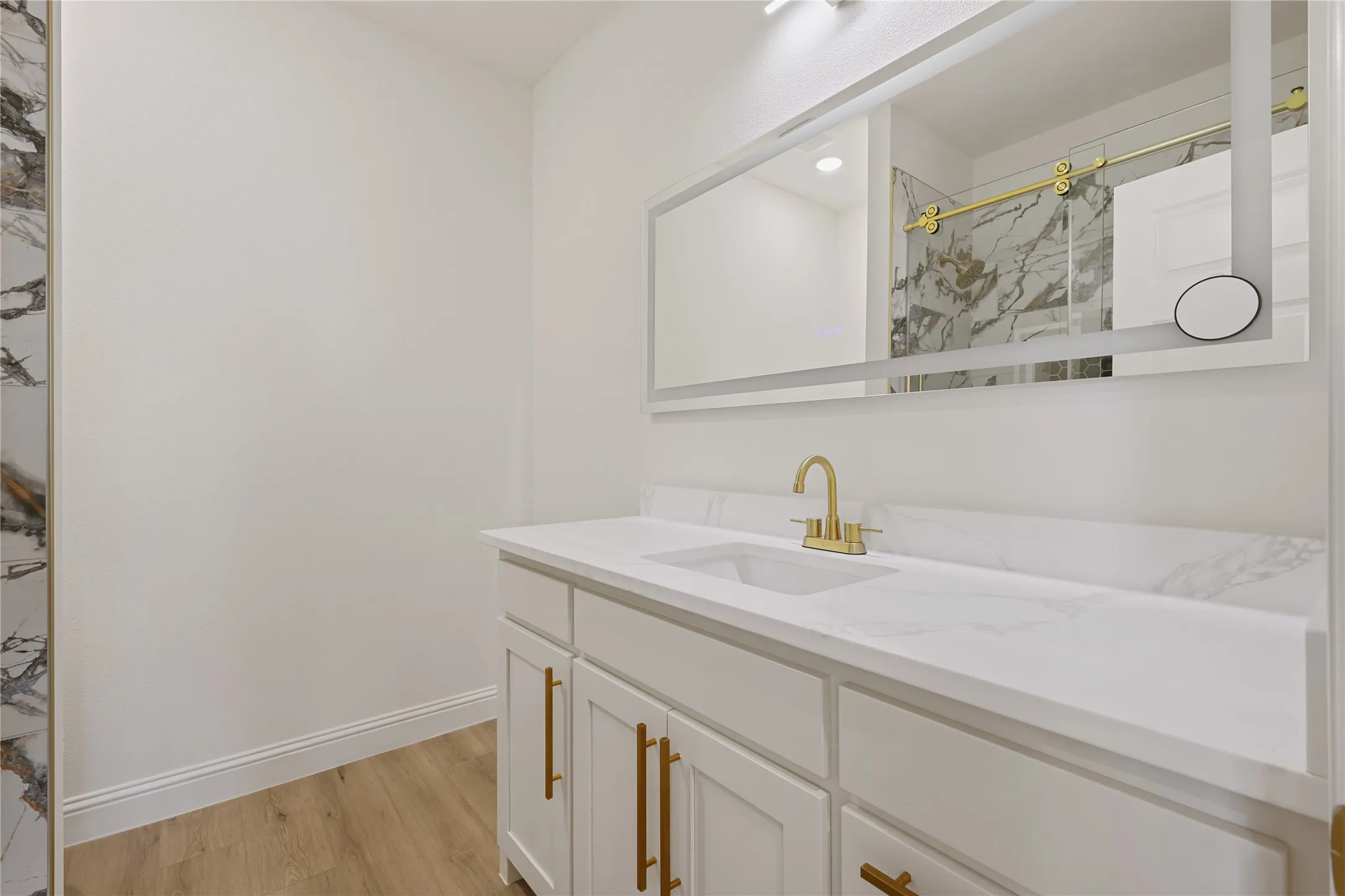 White vanity with gold-finish hardware and faucet