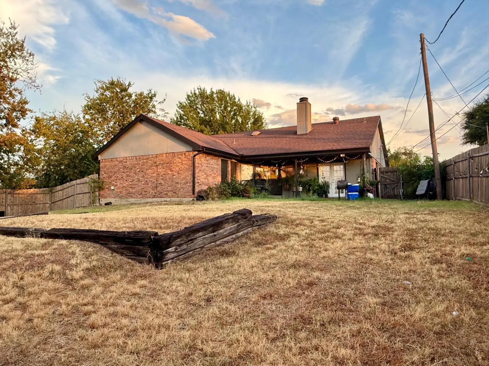 Brick exterior featuring a gabled roofline, chimney, and a covered back patio