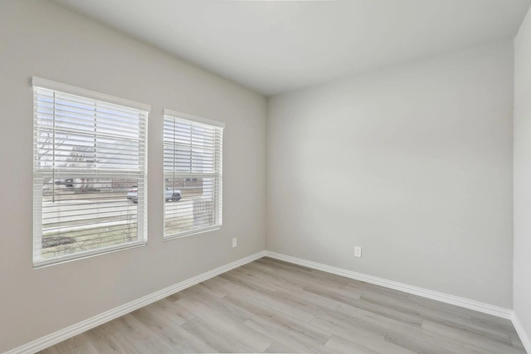 Neutral gray wall paint, white trim, and wood-finish flooring