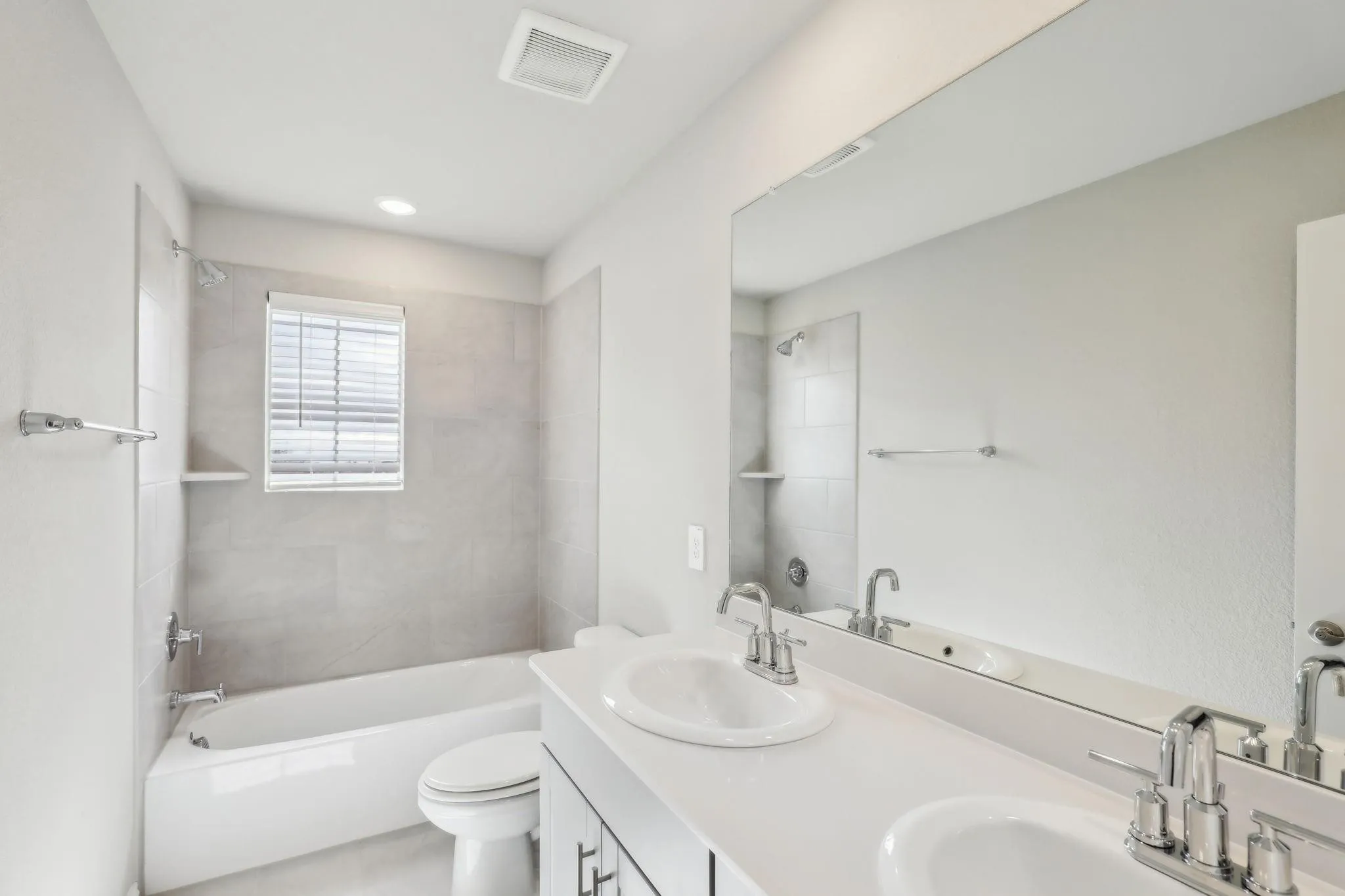 Dual vanity with undermount sinks, chrome fixtures, and a large mirror