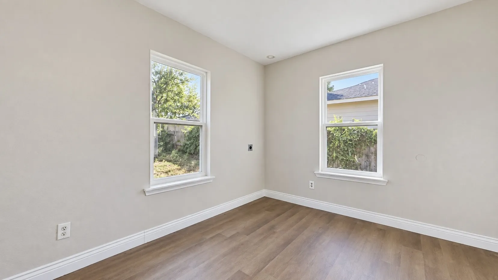 Neutral wall finishes, wood-finish flooring, and white window trim