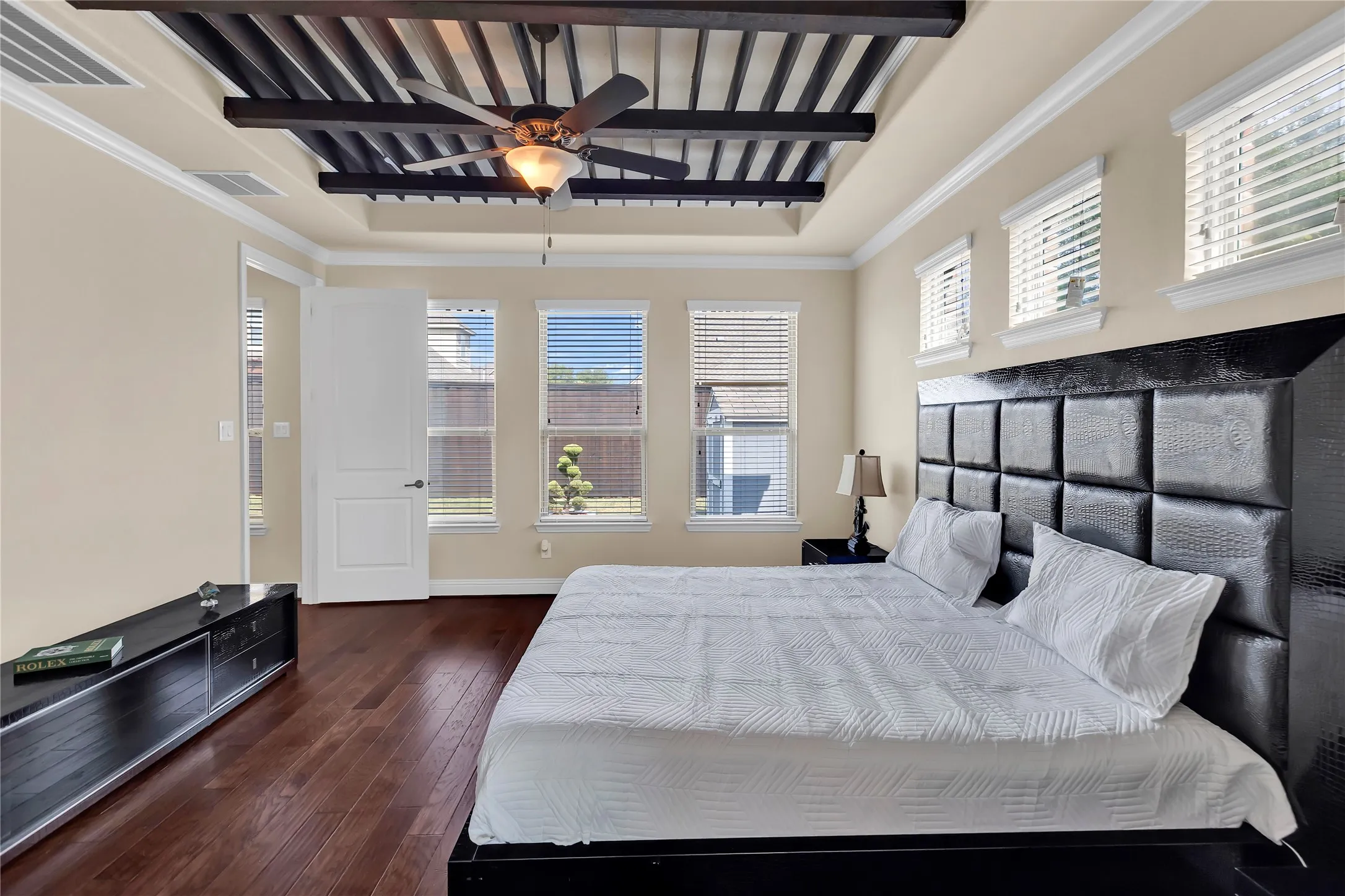 Tray ceiling with wood slat detailing and a ceiling fan