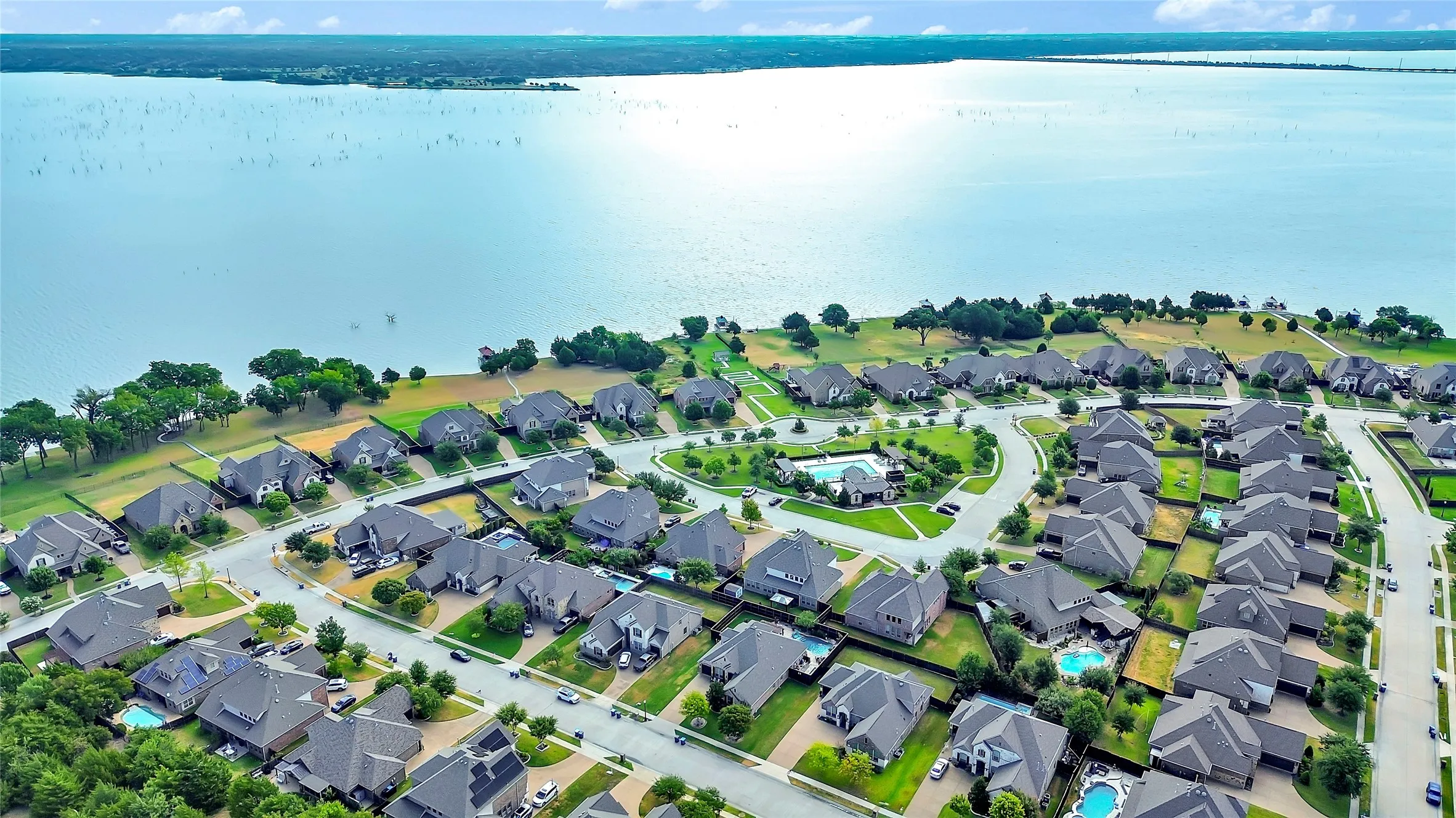 Waterfront community with a broad expanse of water, tree-lined shores, and a developed residential area