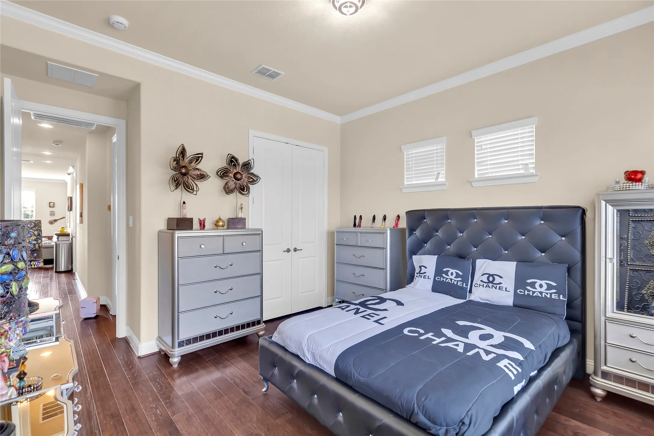 Bedroom in guest suite- Wood-finish flooring, crown molding, and neutral wall tones