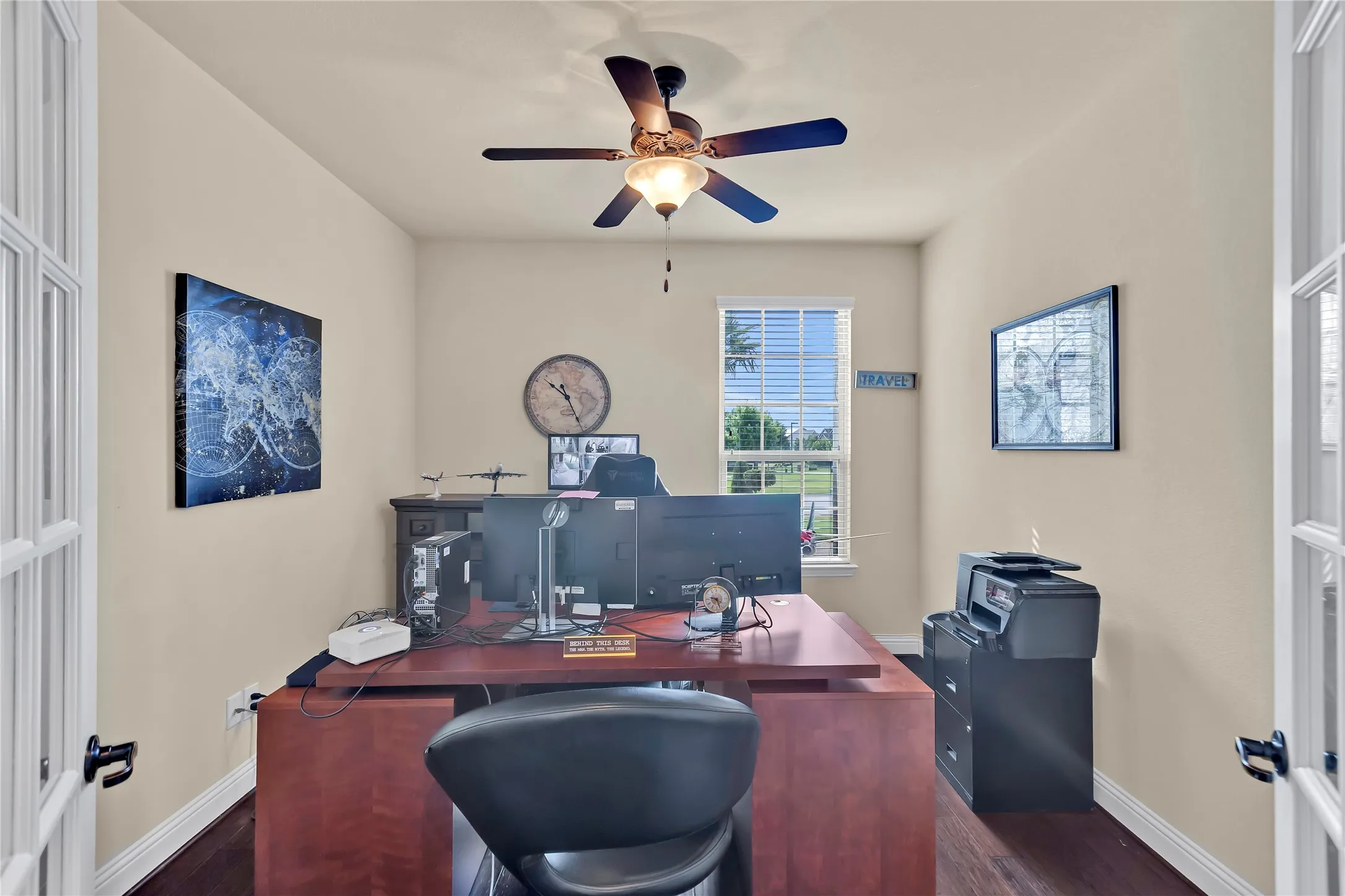 Room featuring wood-finish flooring, a ceiling fan with light, and a single window with blinds
