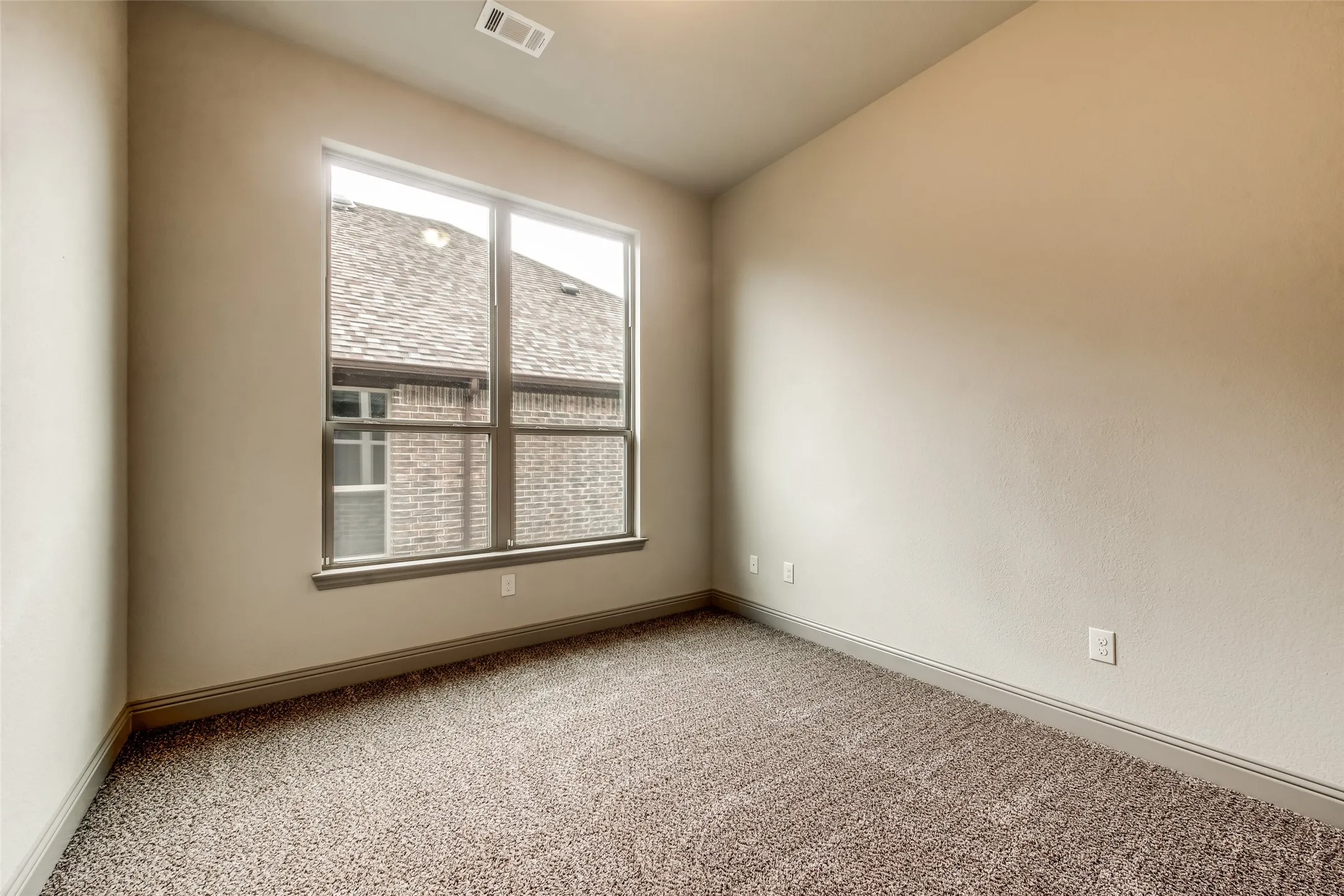Neutral wall finishes, textured carpeting, contemporary window, and recessed lighting